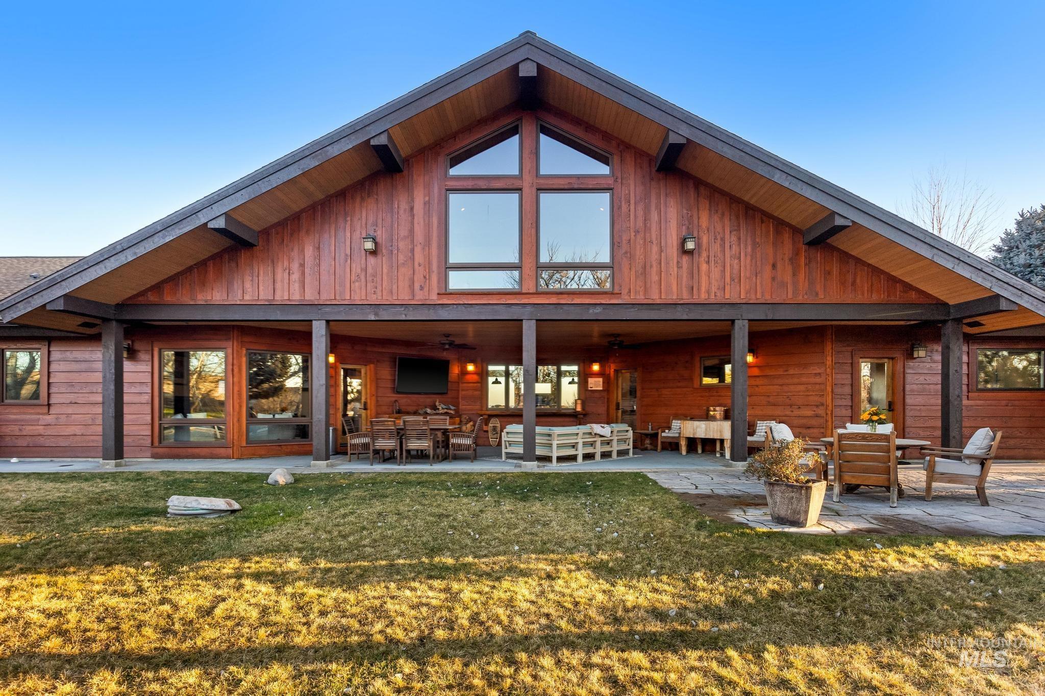 Back of house featuring extensive patio area, huge lawn area, extended paved patio and hot tub area