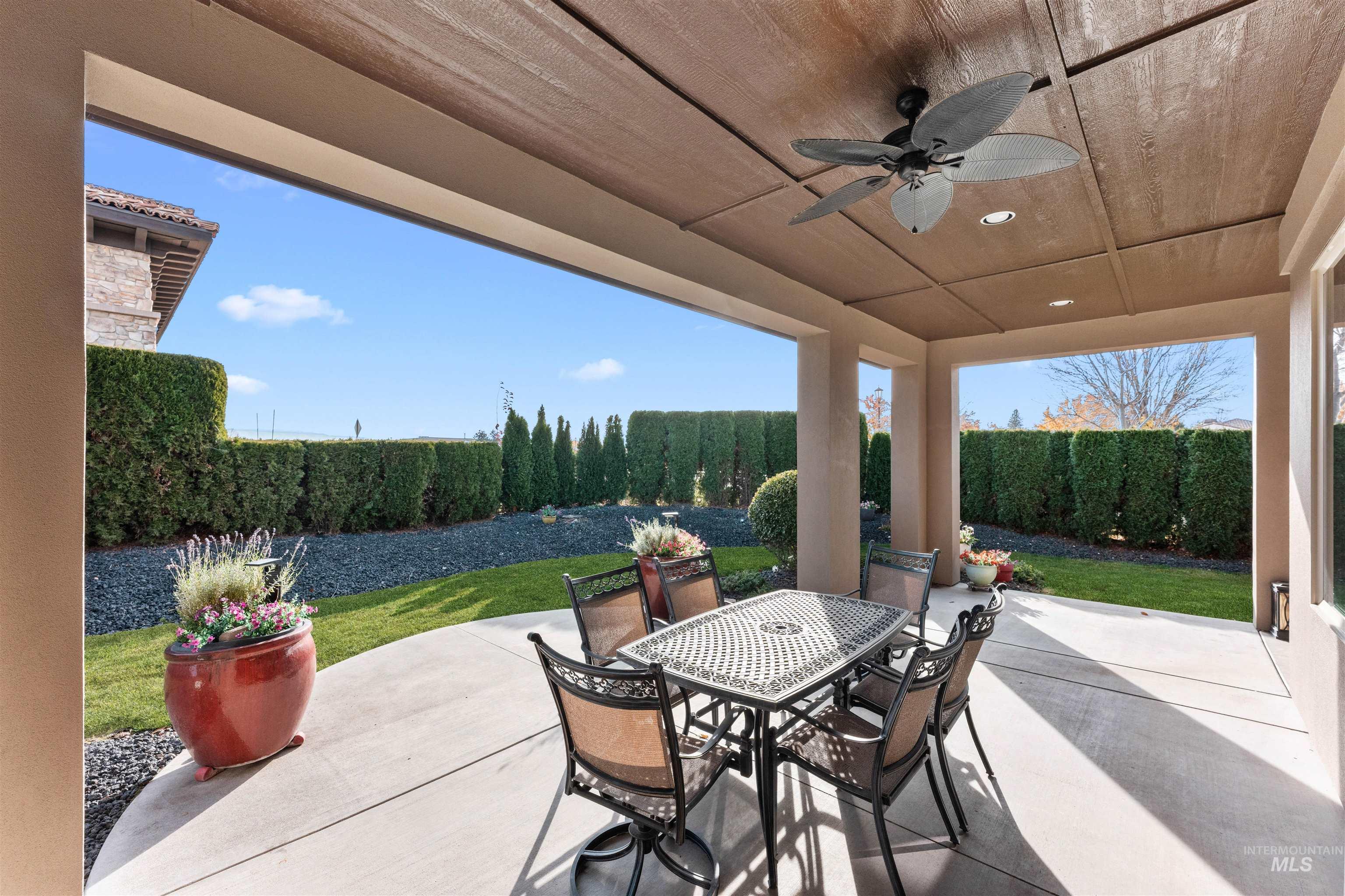 Fenced backyard with a patio, ceiling fan, and outdoor dining area