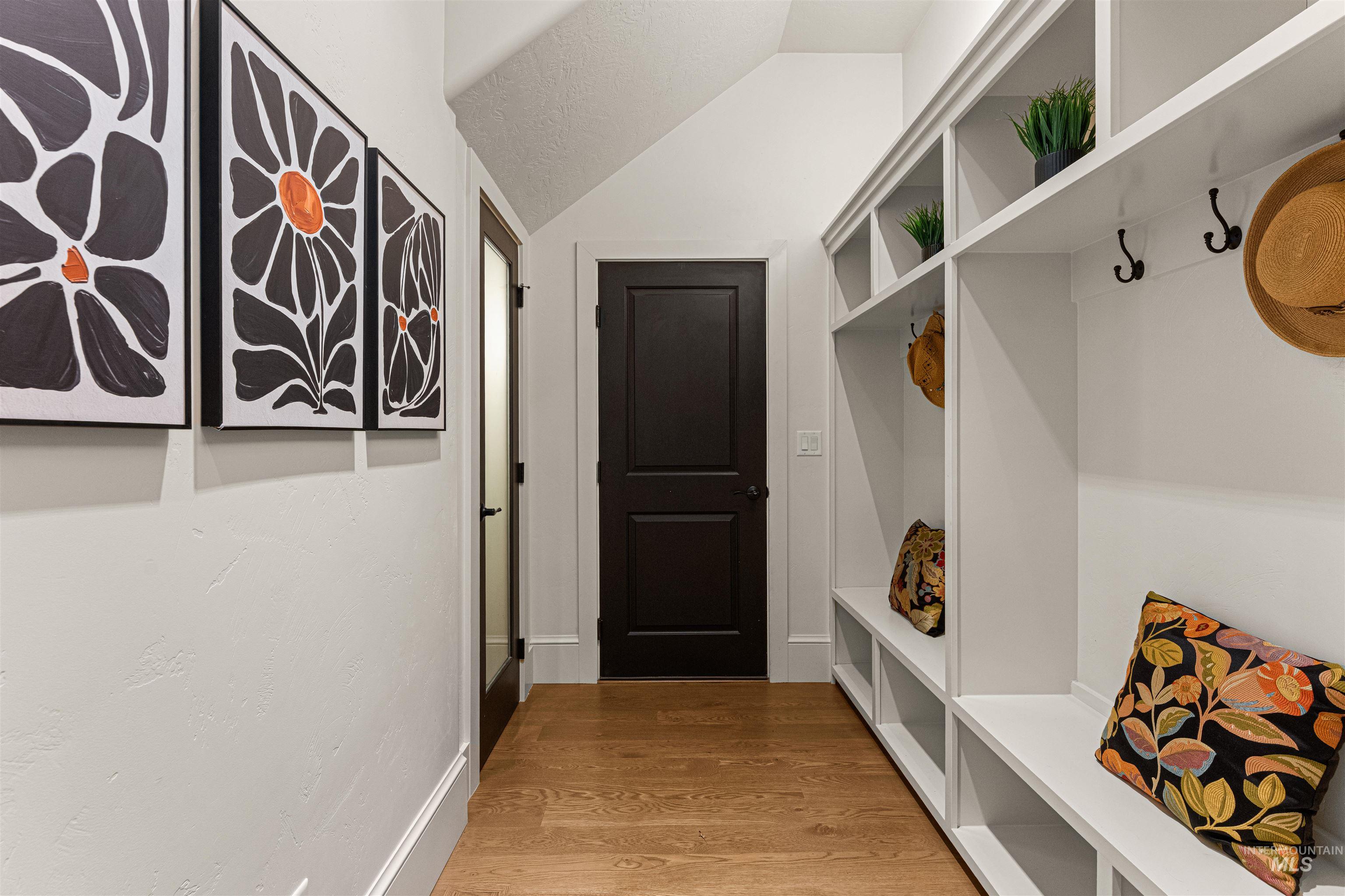 Mudroom featuring light wood-type flooring and lofted ceiling