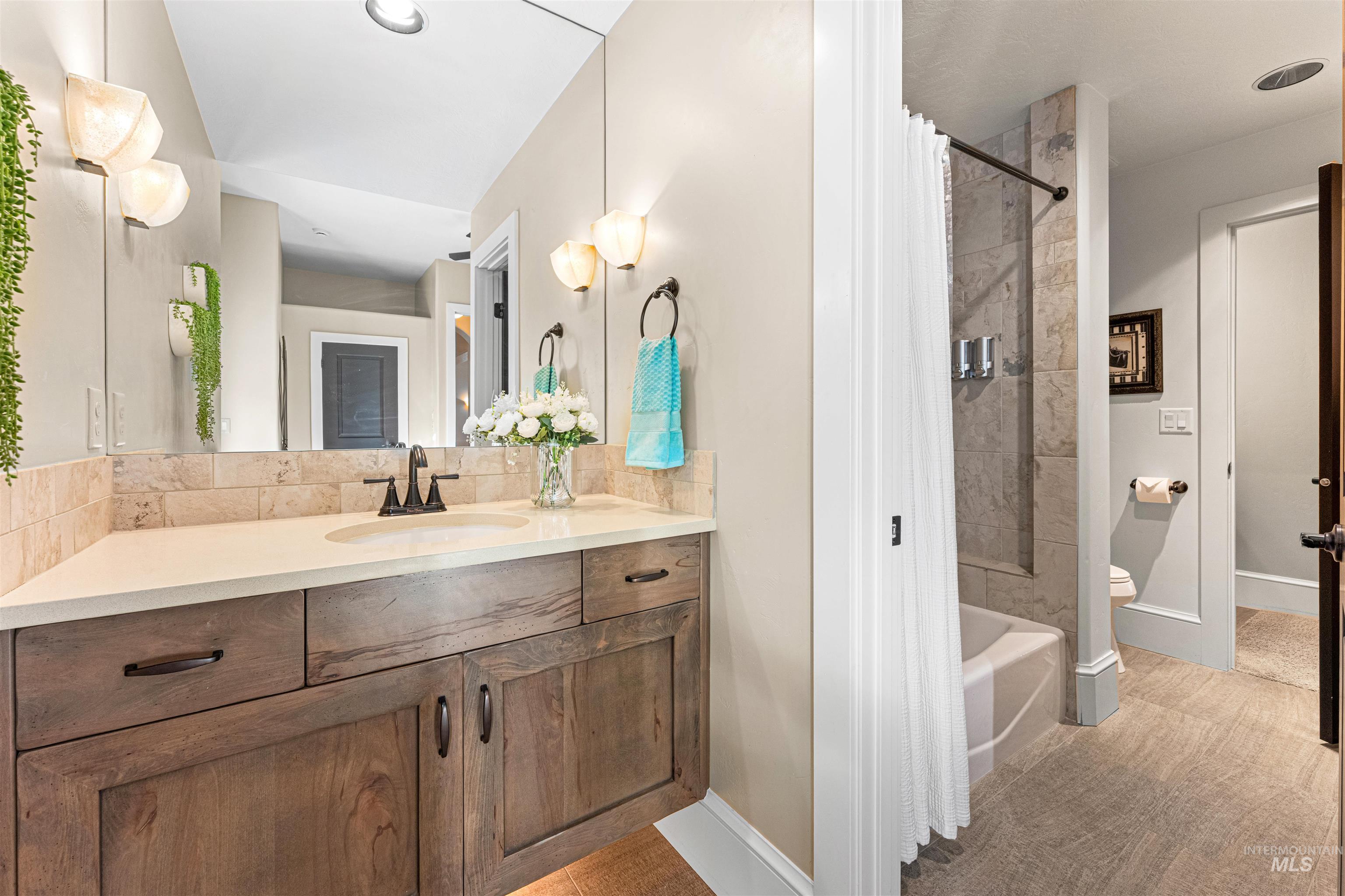 Full bathroom featuring vanity, shower / tub combo with curtain, and light tile patterned floors