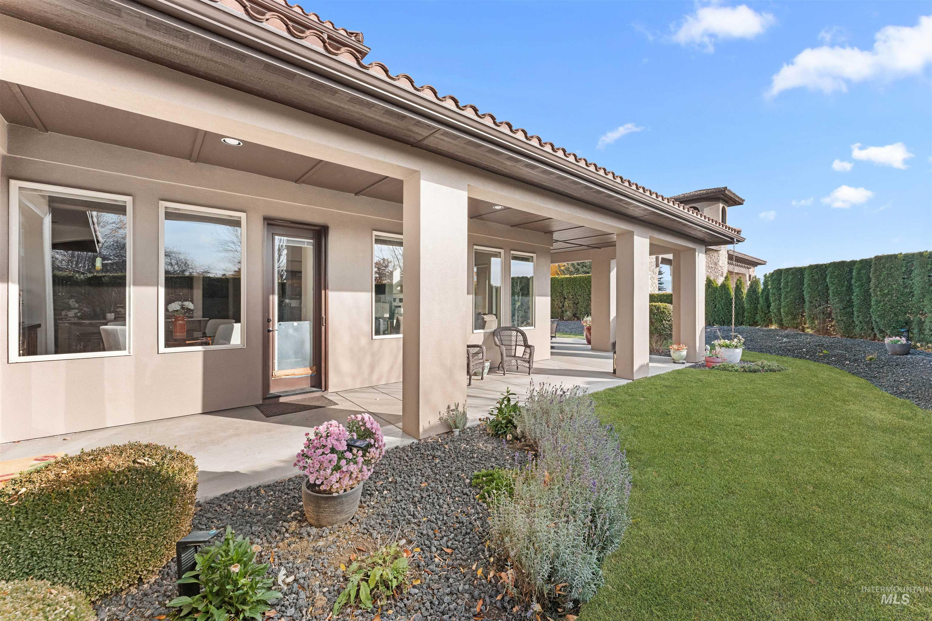 Back of property with a yard, stucco siding, and a patio