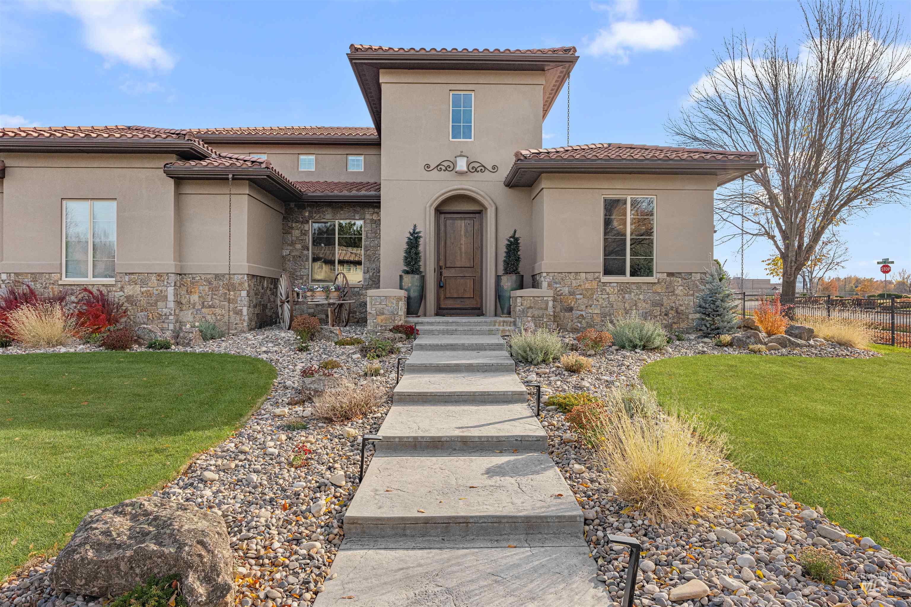 Mediterranean / spanish home featuring stone siding, stucco siding, and a tile roof