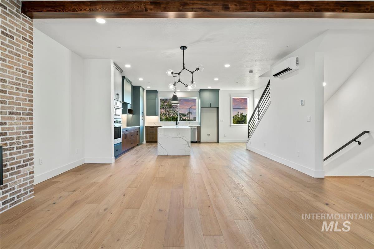 Kitchen featuring open floor plan, light wood-style floors, decorative light fixtures, a kitchen island, and recessed lighting