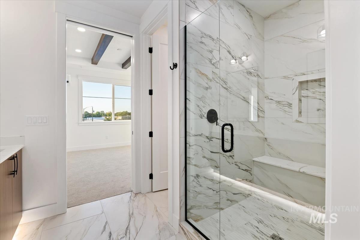 Bathroom featuring light marble finish floors, vanity, beam ceiling, a marble finish shower, and recessed lighting