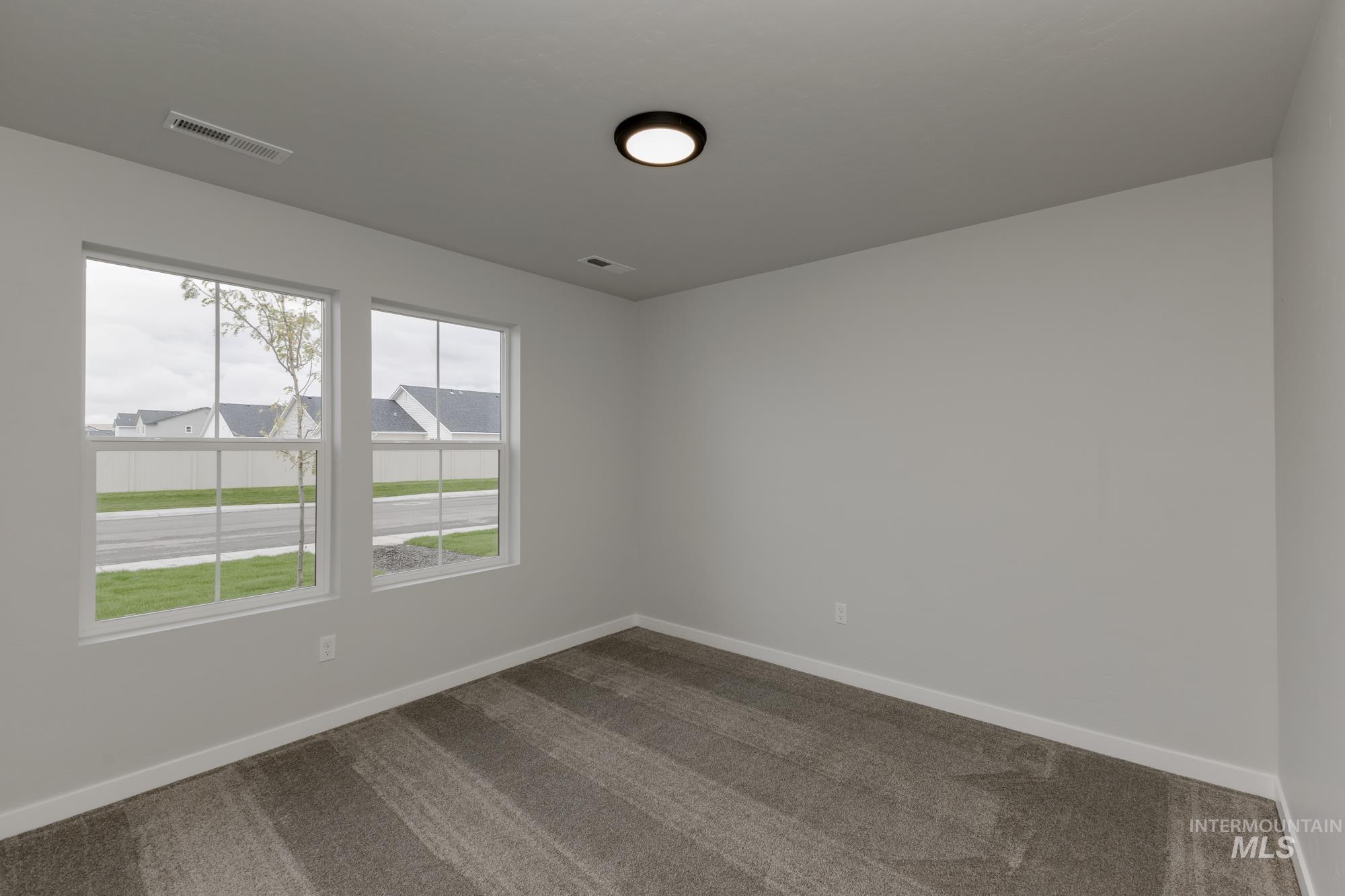 Empty room featuring carpet flooring and baseboards