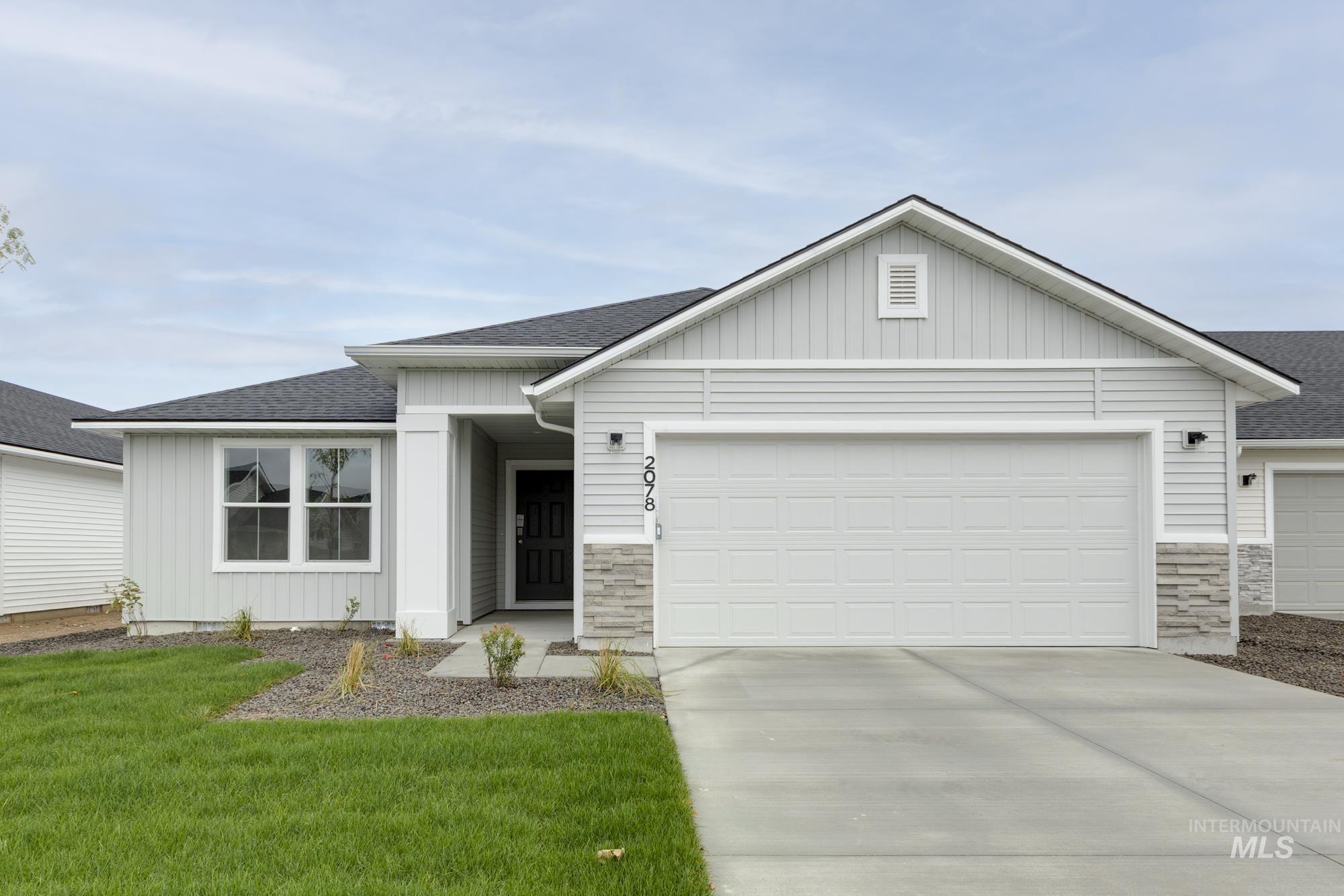 Ranch-style house with roof with shingles, board and batten siding, stone siding, and driveway