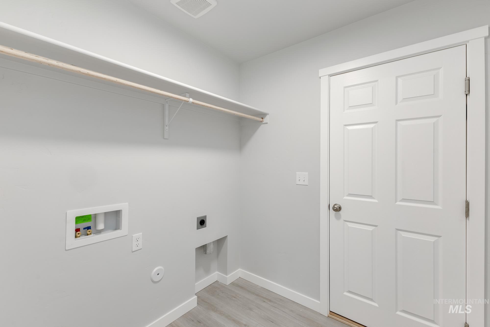 Laundry room with light wood finished floors, washer hookup, and hookup for an electric dryer