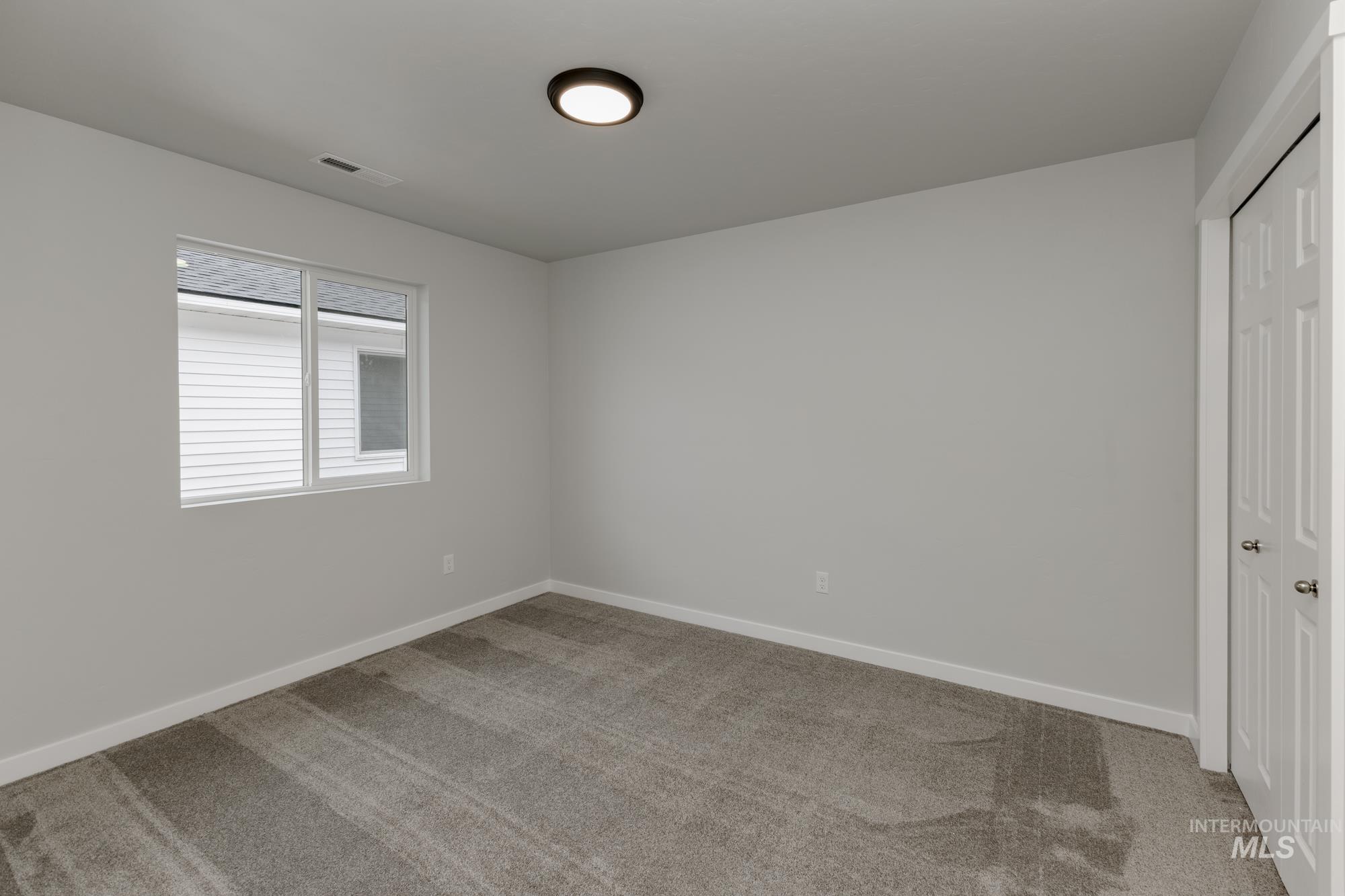 Unfurnished bedroom with light colored carpet and a closet