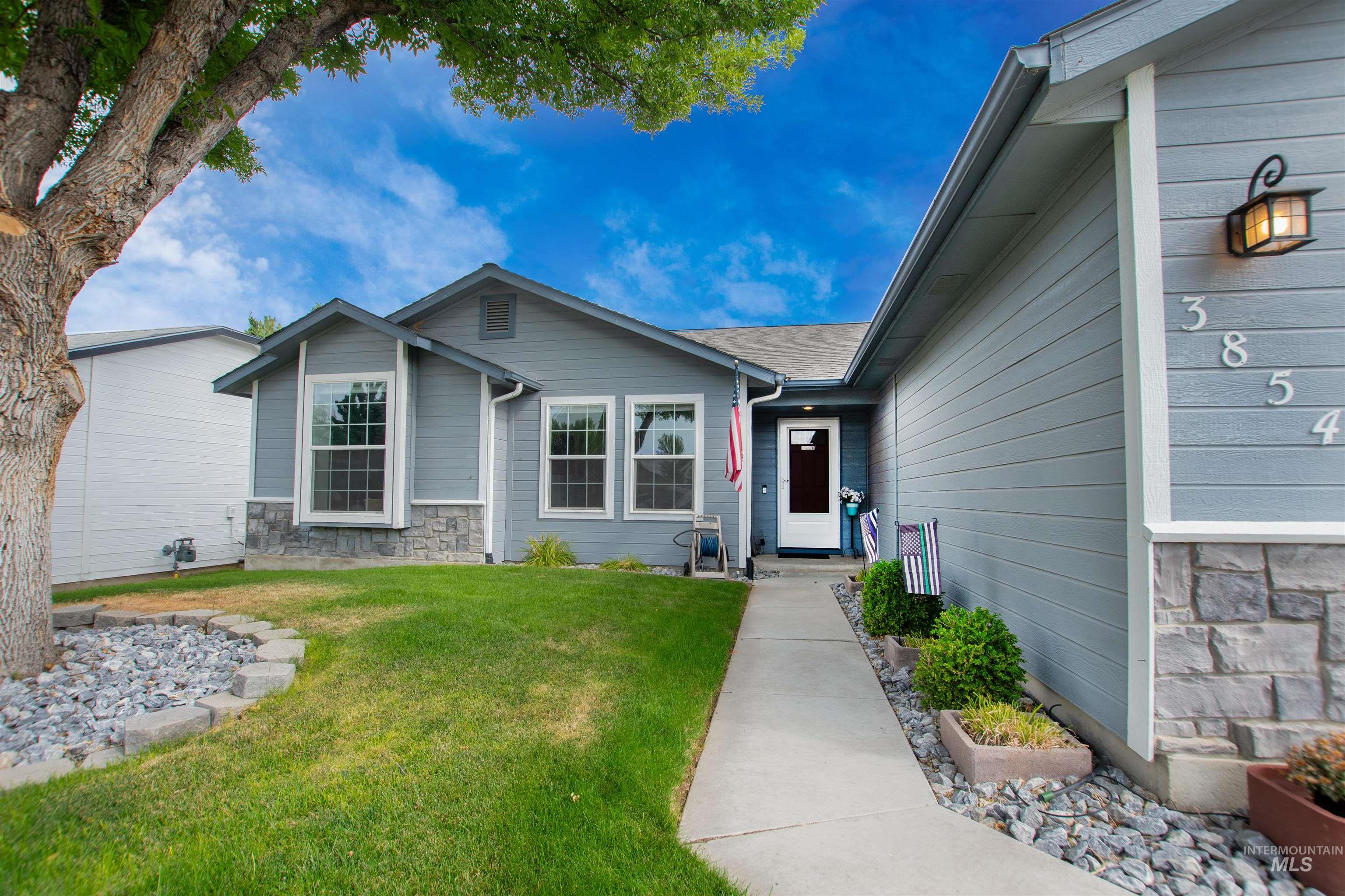 View of front of home with stone siding and a front yard