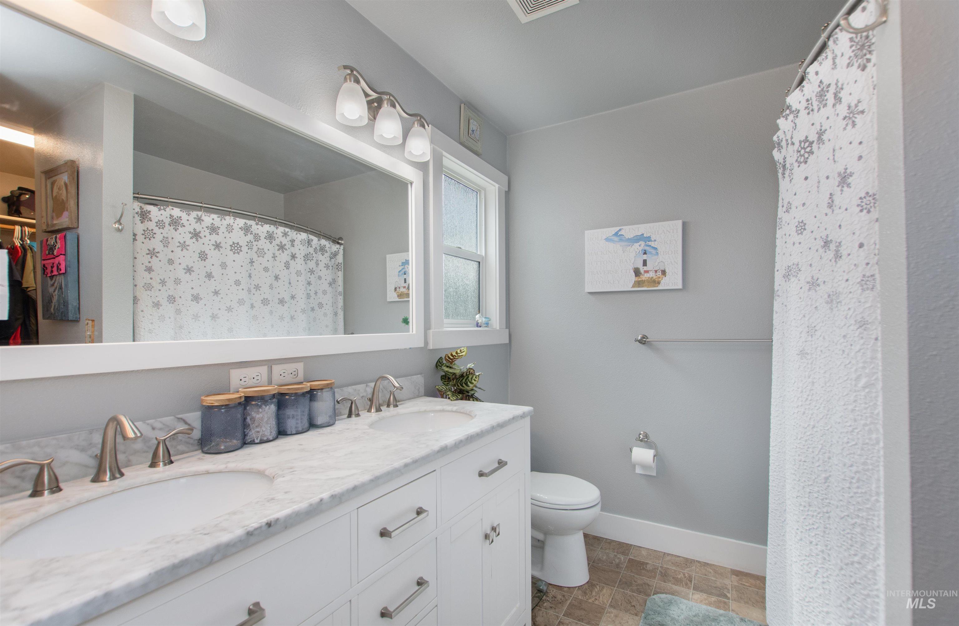 Full bath with a walk in closet, double vanity, and a shower with curtain