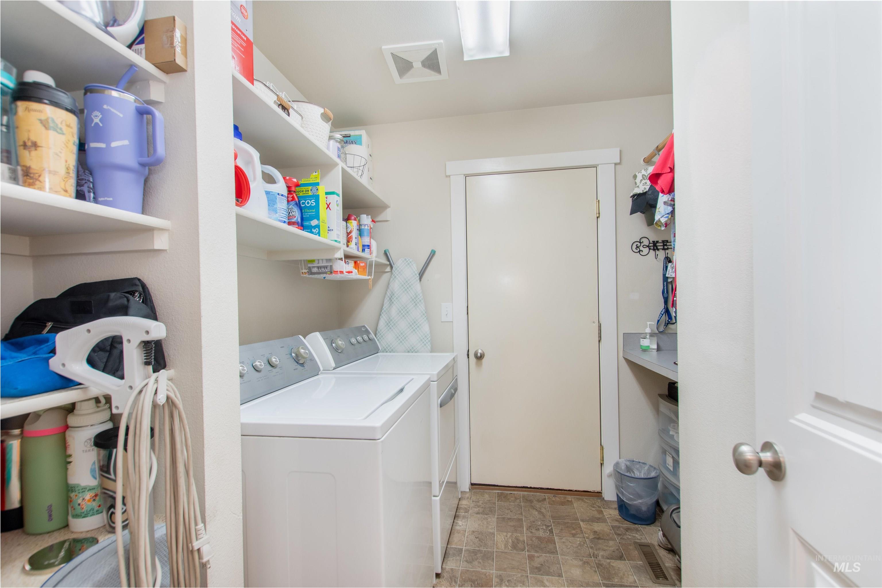 Washroom featuring stone finish floors and washer and clothes dryer
