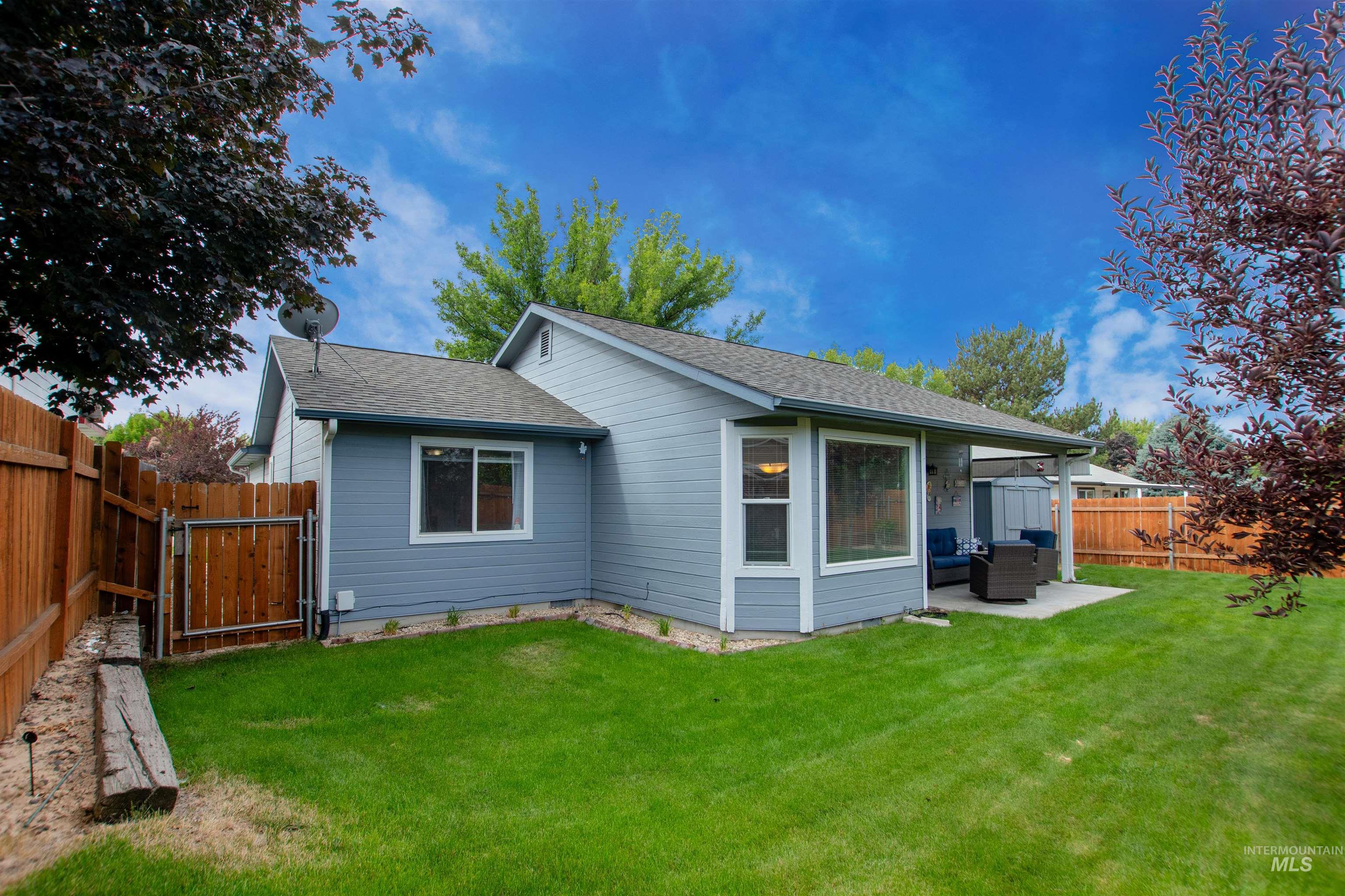 Back of house with a shingled roof, a fenced backyard, a patio area, and a gate