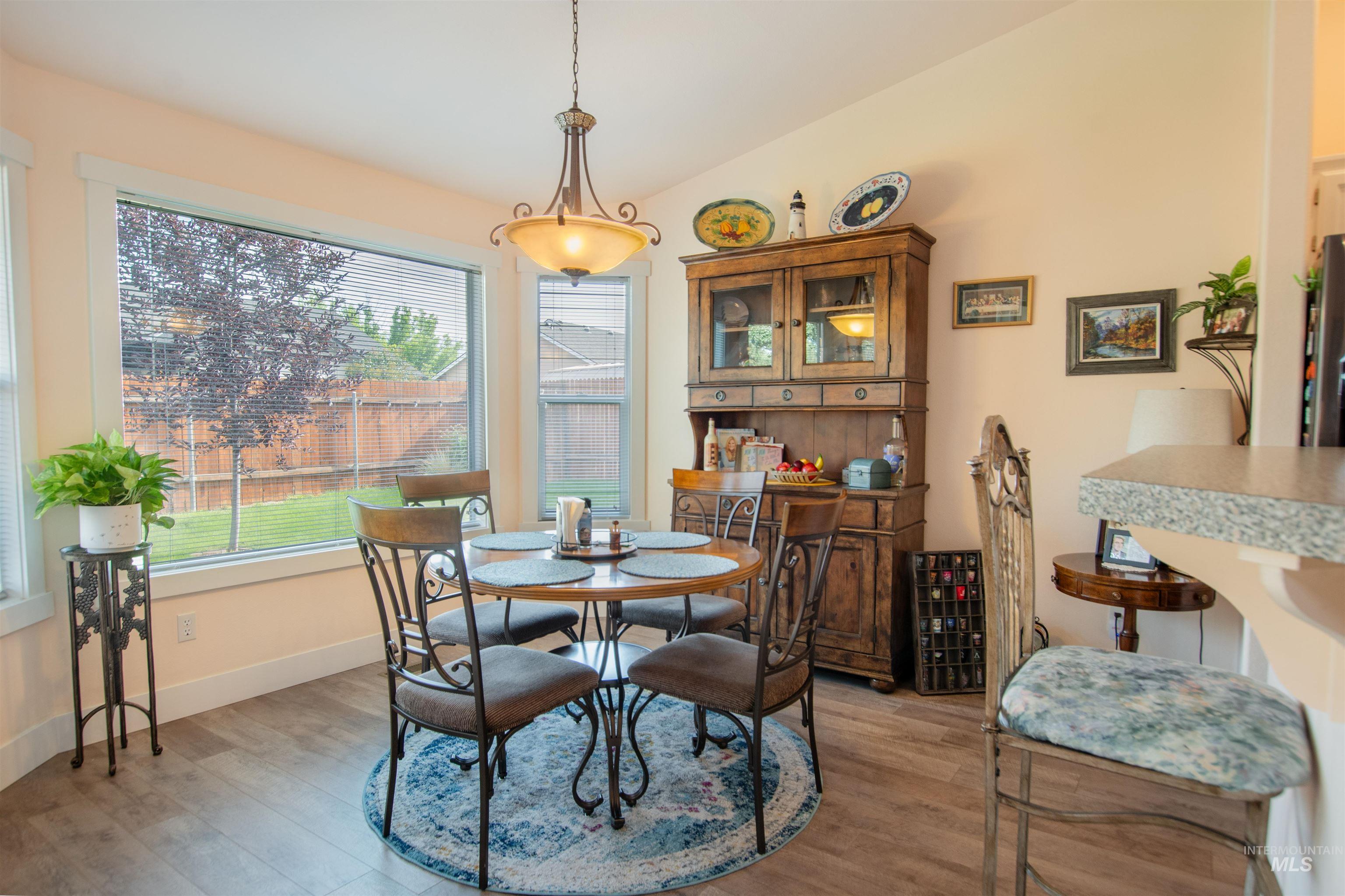 Dining room featuring light wood-type flooring and lofted ceiling
