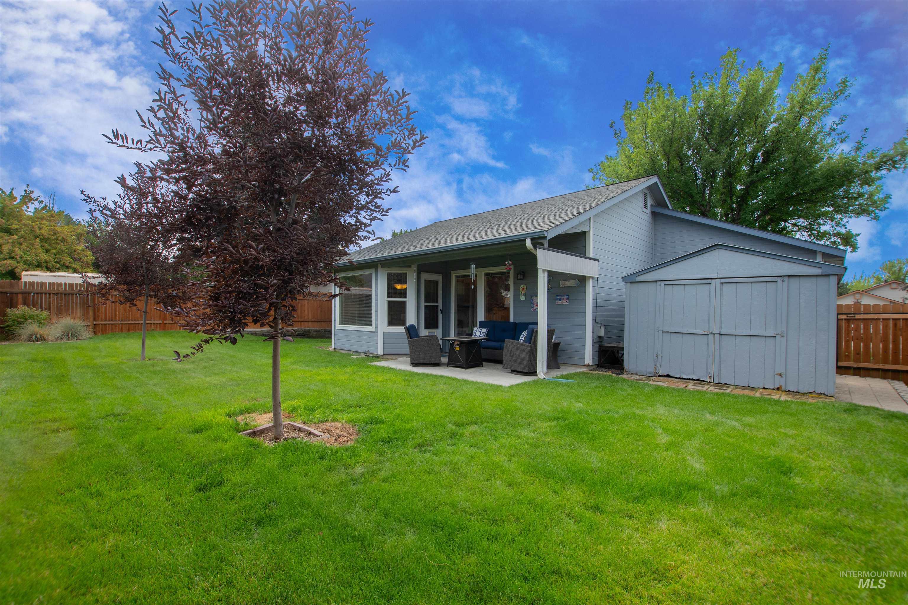 Rear view of property with a patio, a storage unit, a shingled roof, and an outdoor hangout area