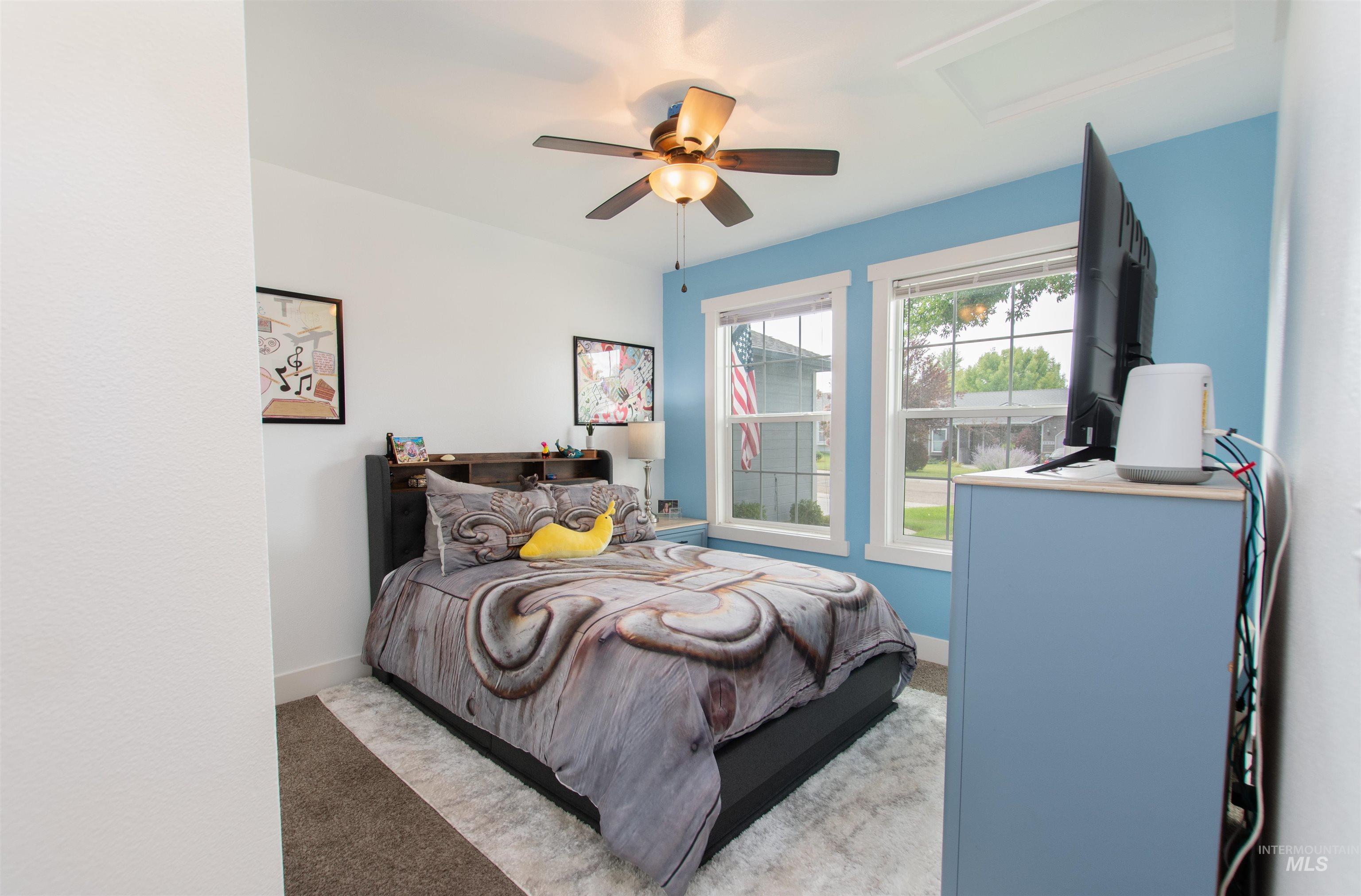 Carpeted bedroom featuring a ceiling fan and attic access