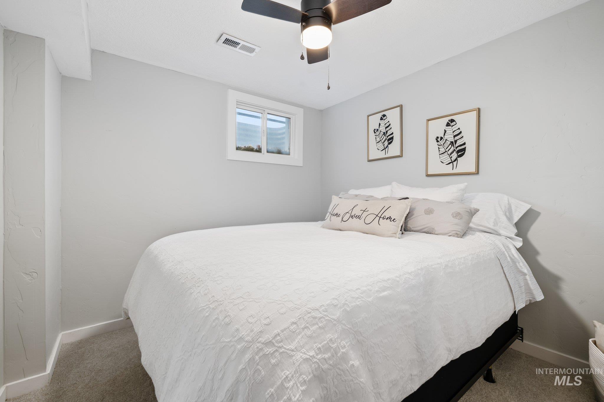 Carpeted bedroom with baseboards and a ceiling fan