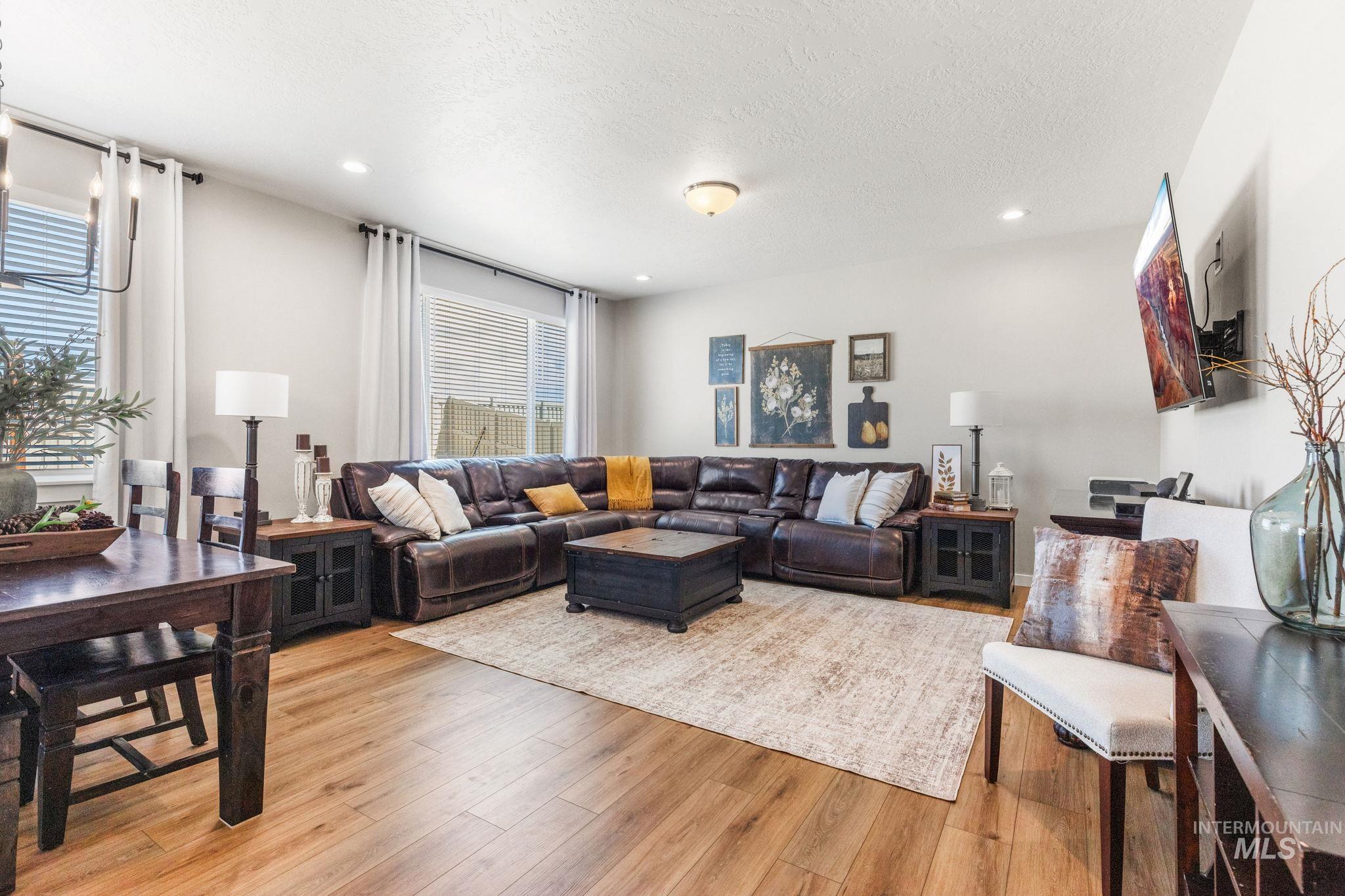 Living room with light wood-style flooring, a textured ceiling, and recessed lighting