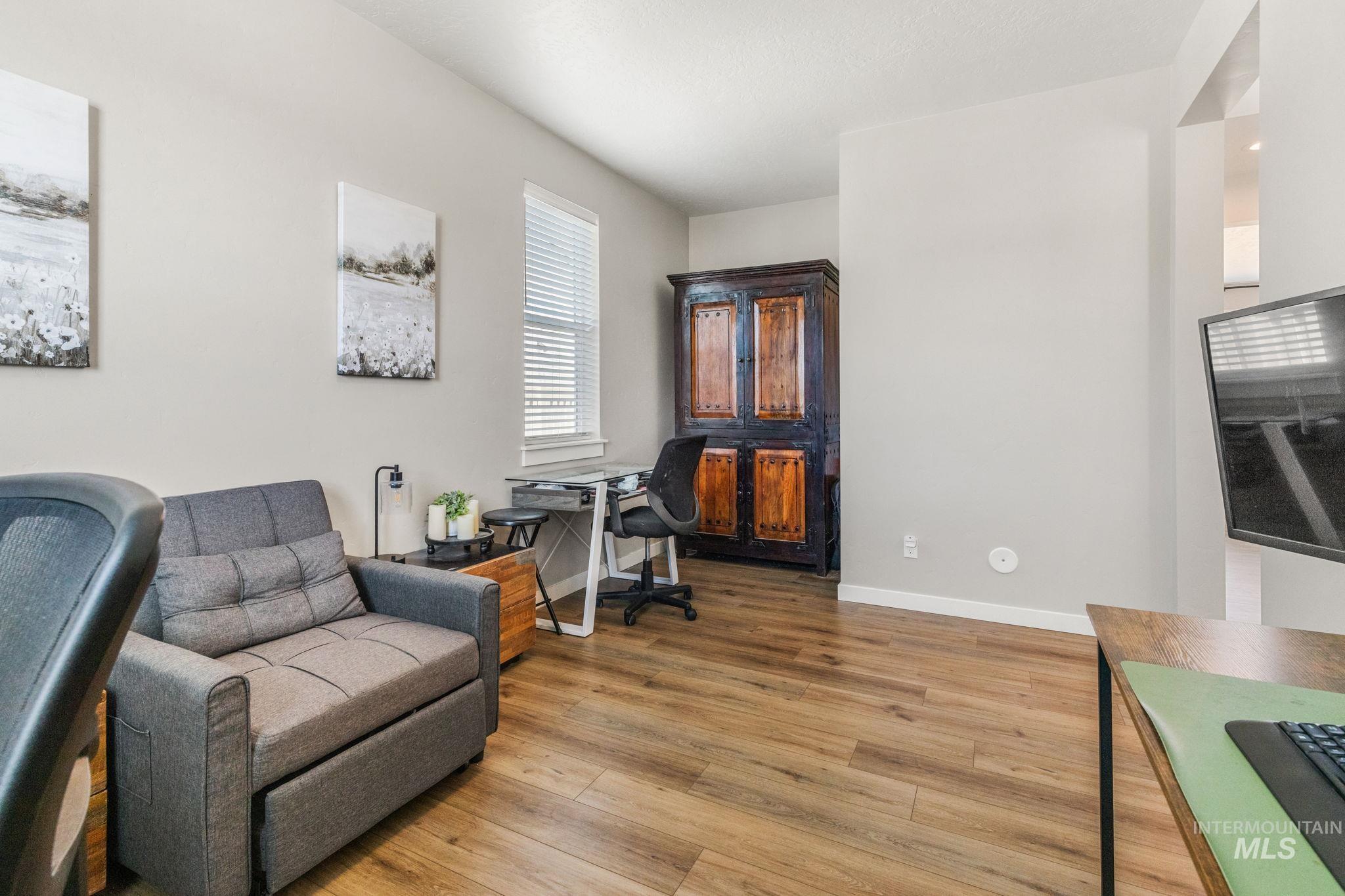 Sitting room with light wood-style floors and a desk