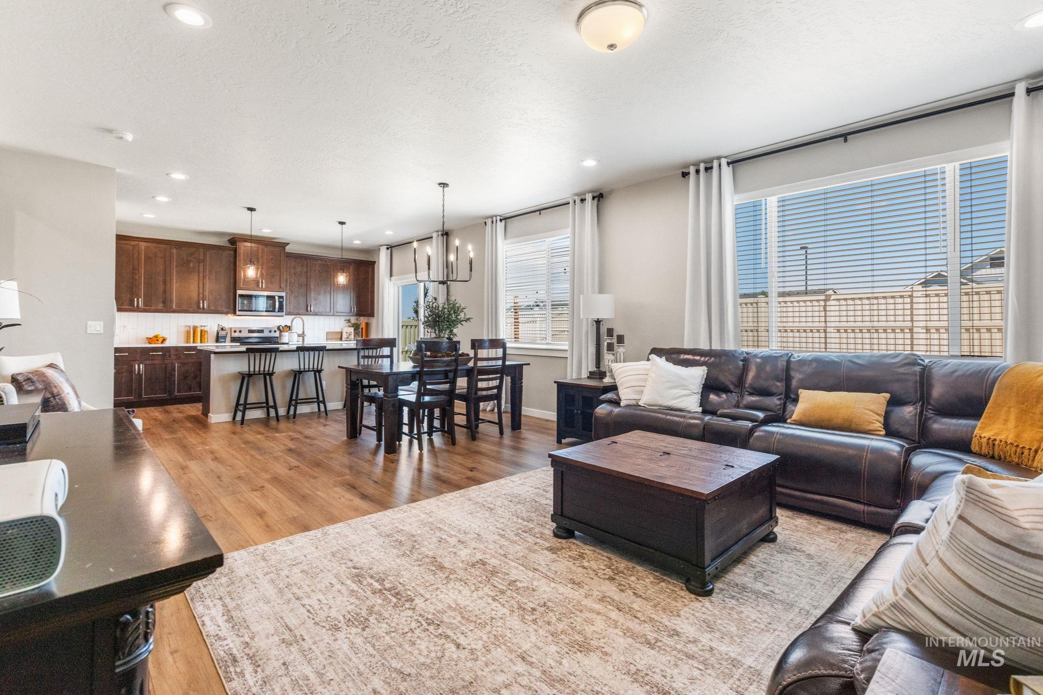 Living area with light wood finished floors, a textured ceiling, and recessed lighting