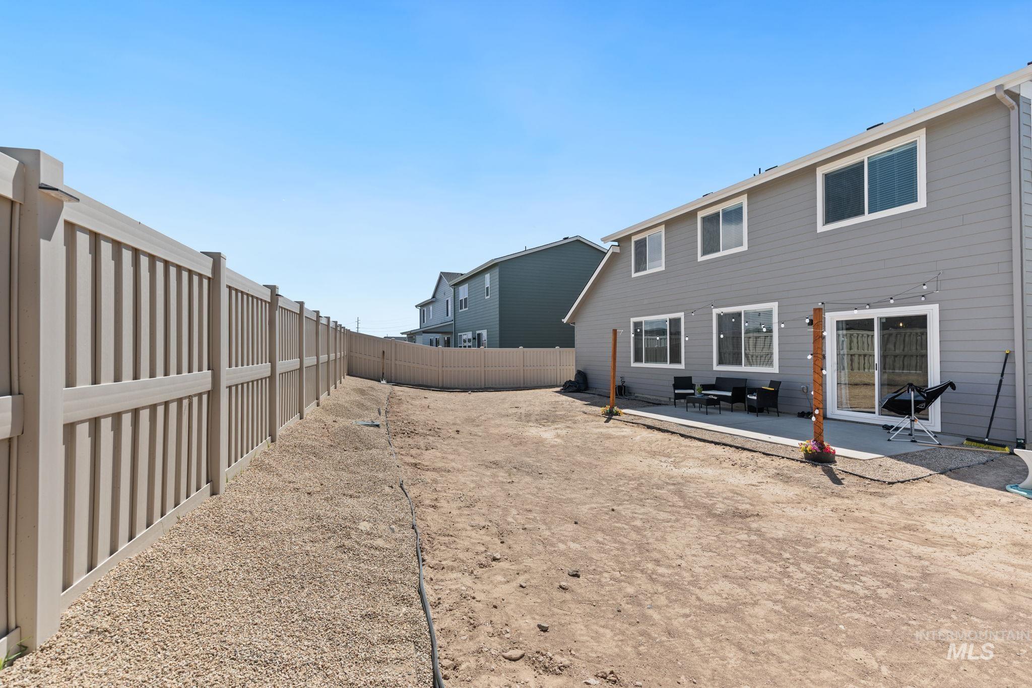 Rear view of house with a patio area and a fenced backyard