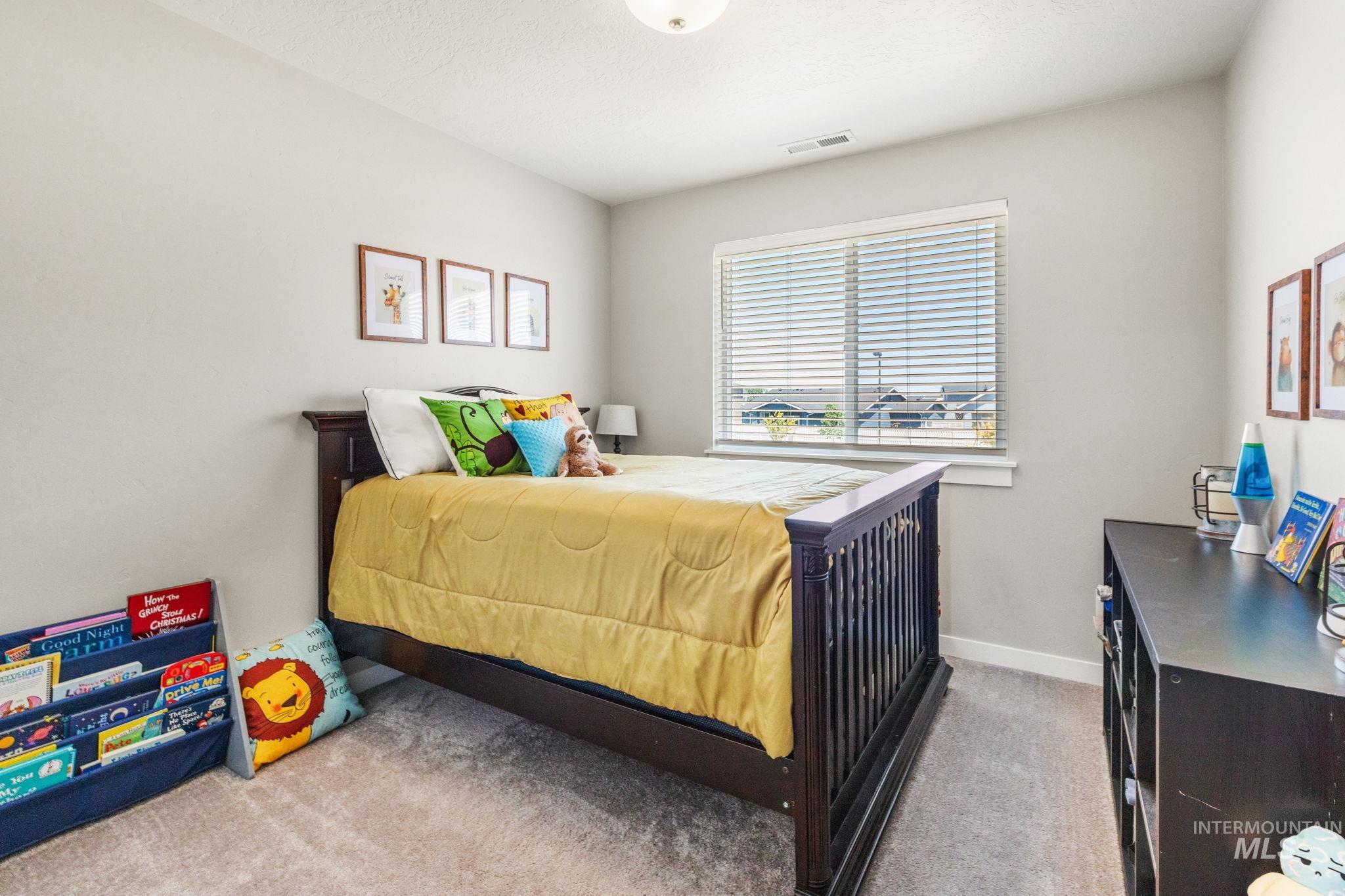 Carpeted bedroom with a textured ceiling and baseboards