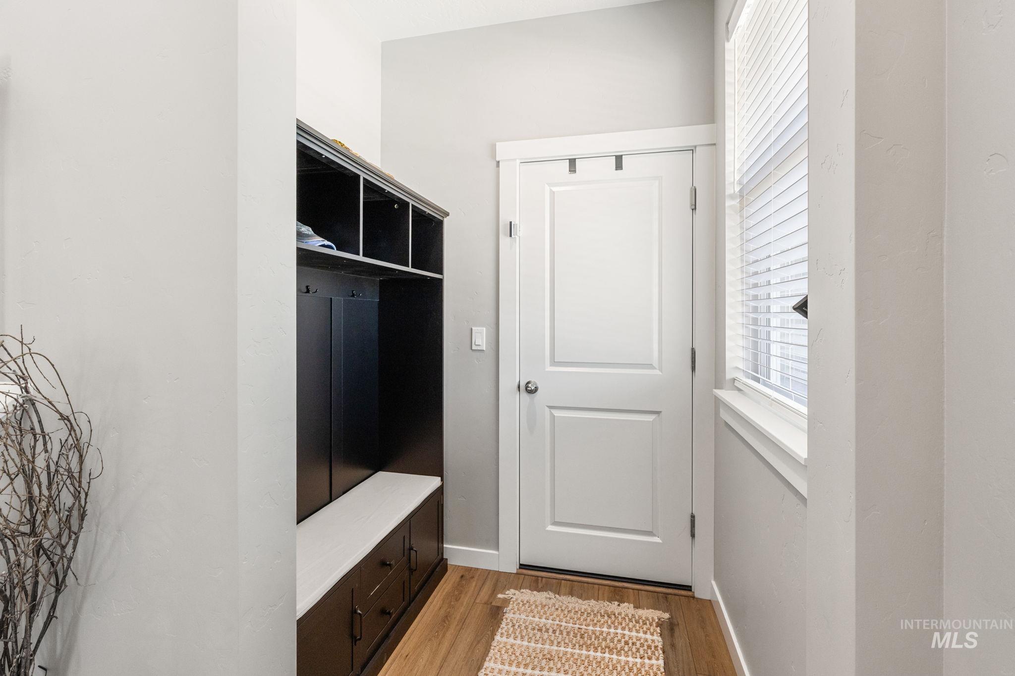 Mudroom with light wood-style flooring and baseboards