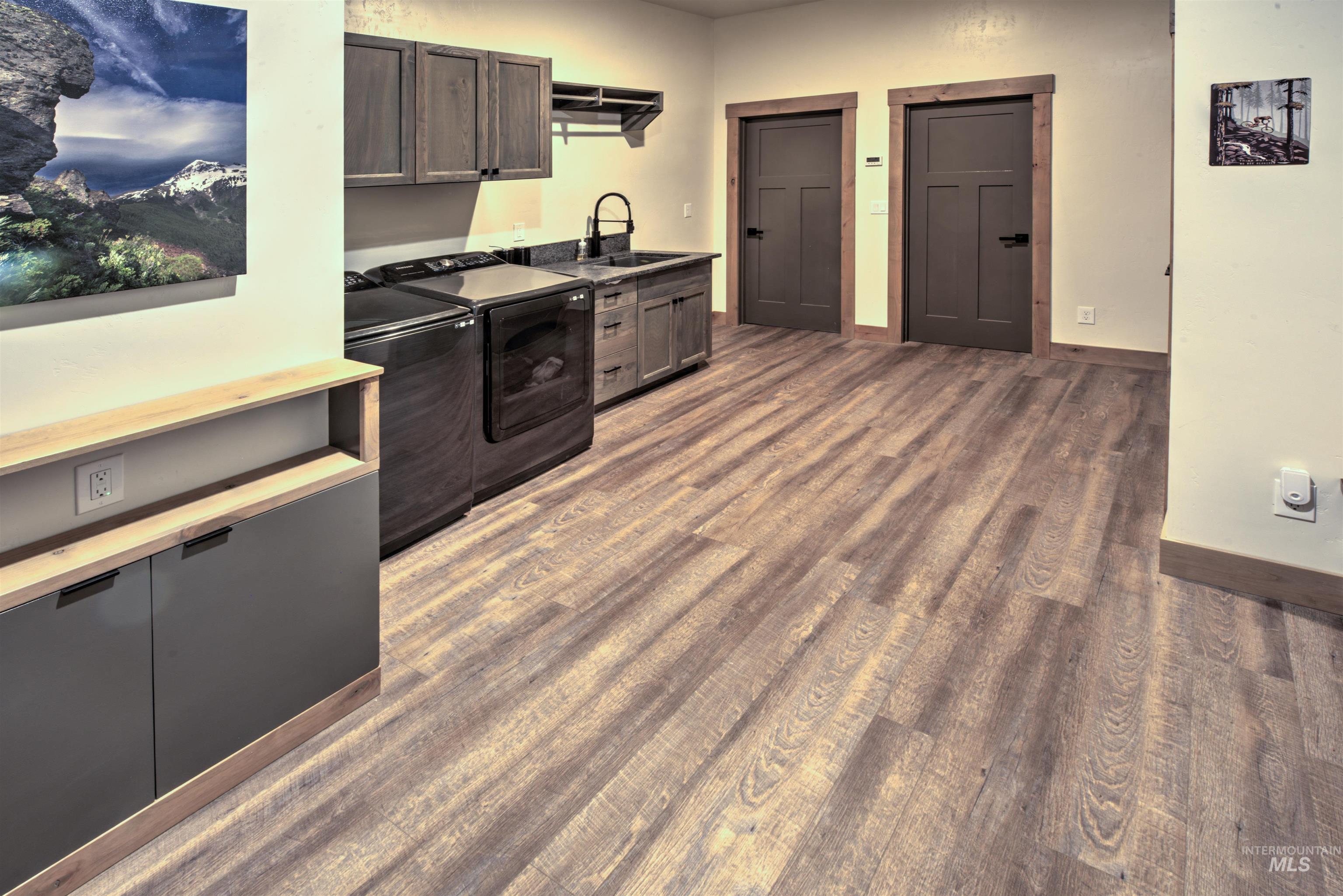 Wood-finish flooring throughout, featuring a built-in cabinetry unit with a light wood-finish top and dark gray doors