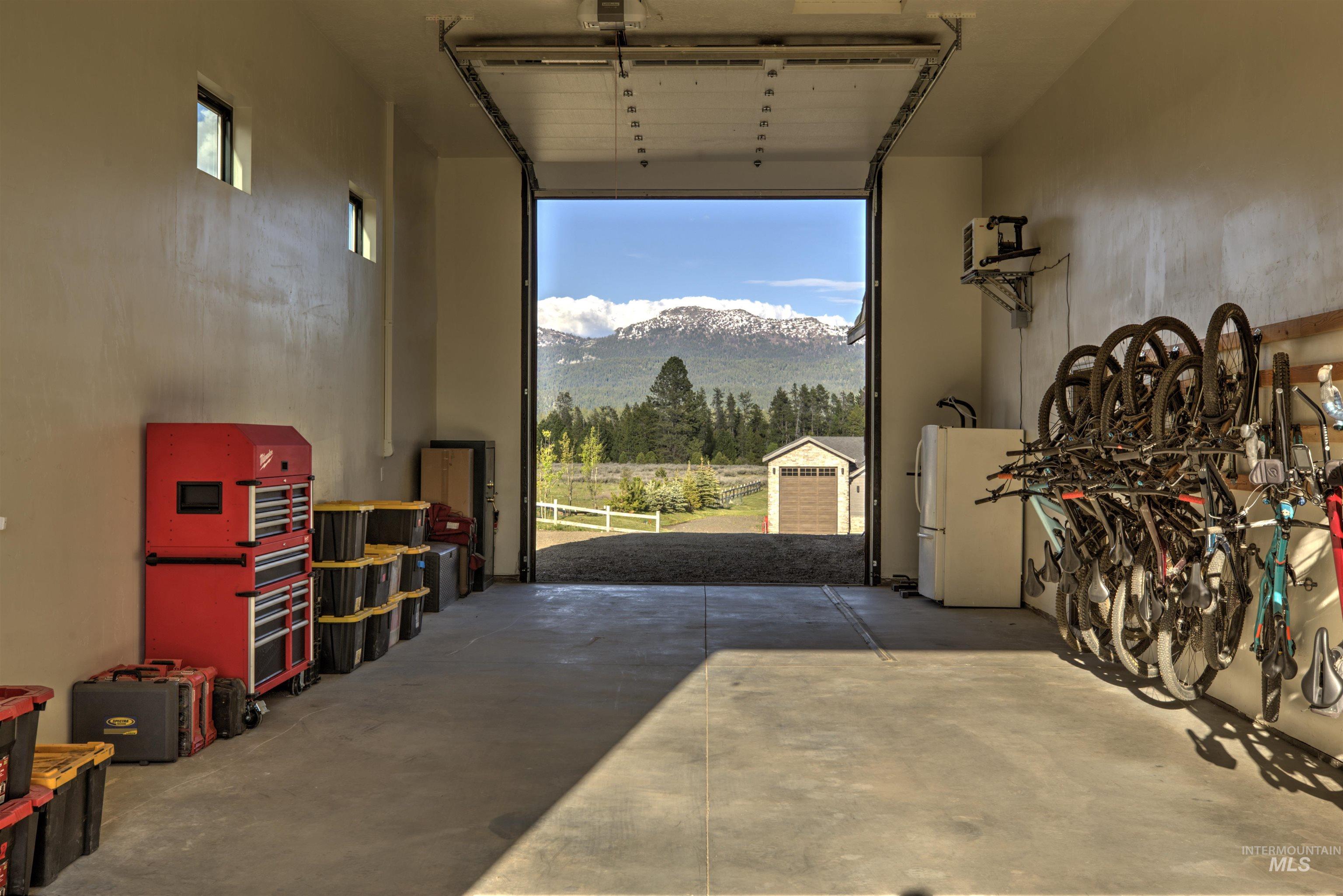 Spacious garage with an open overhead door revealing a scenic mountain backdrop