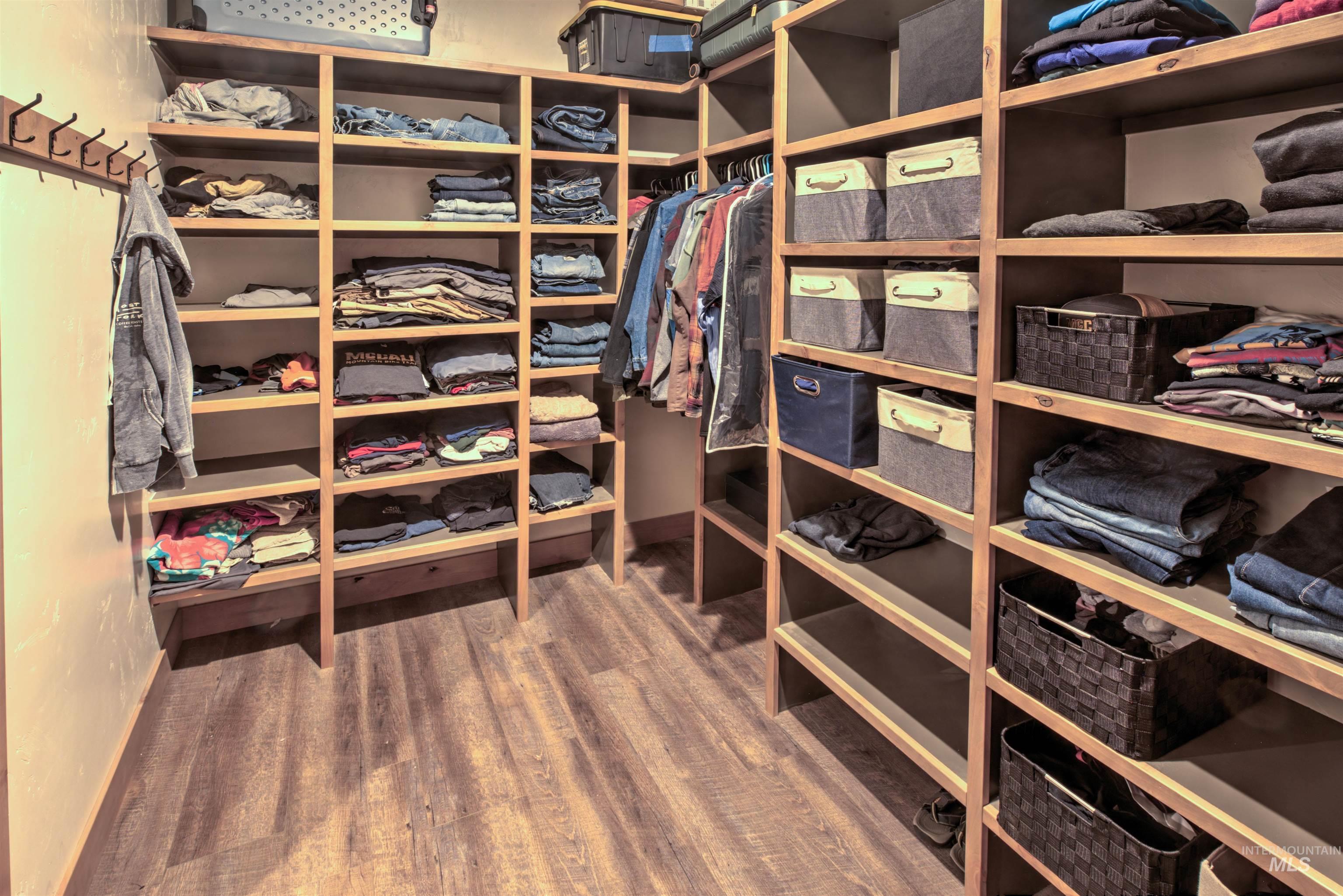 Custom-built organizational system featuring multiple shelving units, integrated hanging rods, and wood-finish flooring