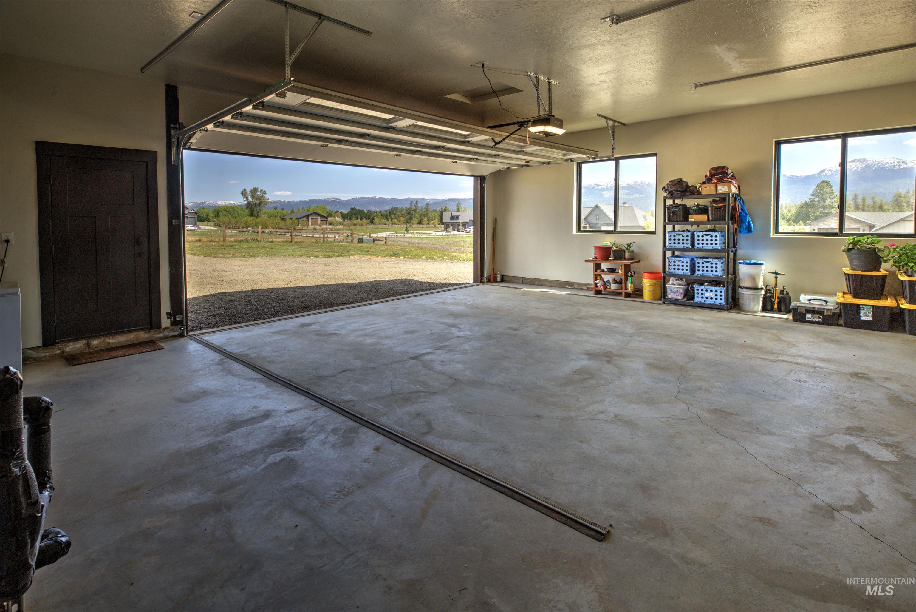 Spacious garage featuring a concrete floor, two windows, and an overhead door