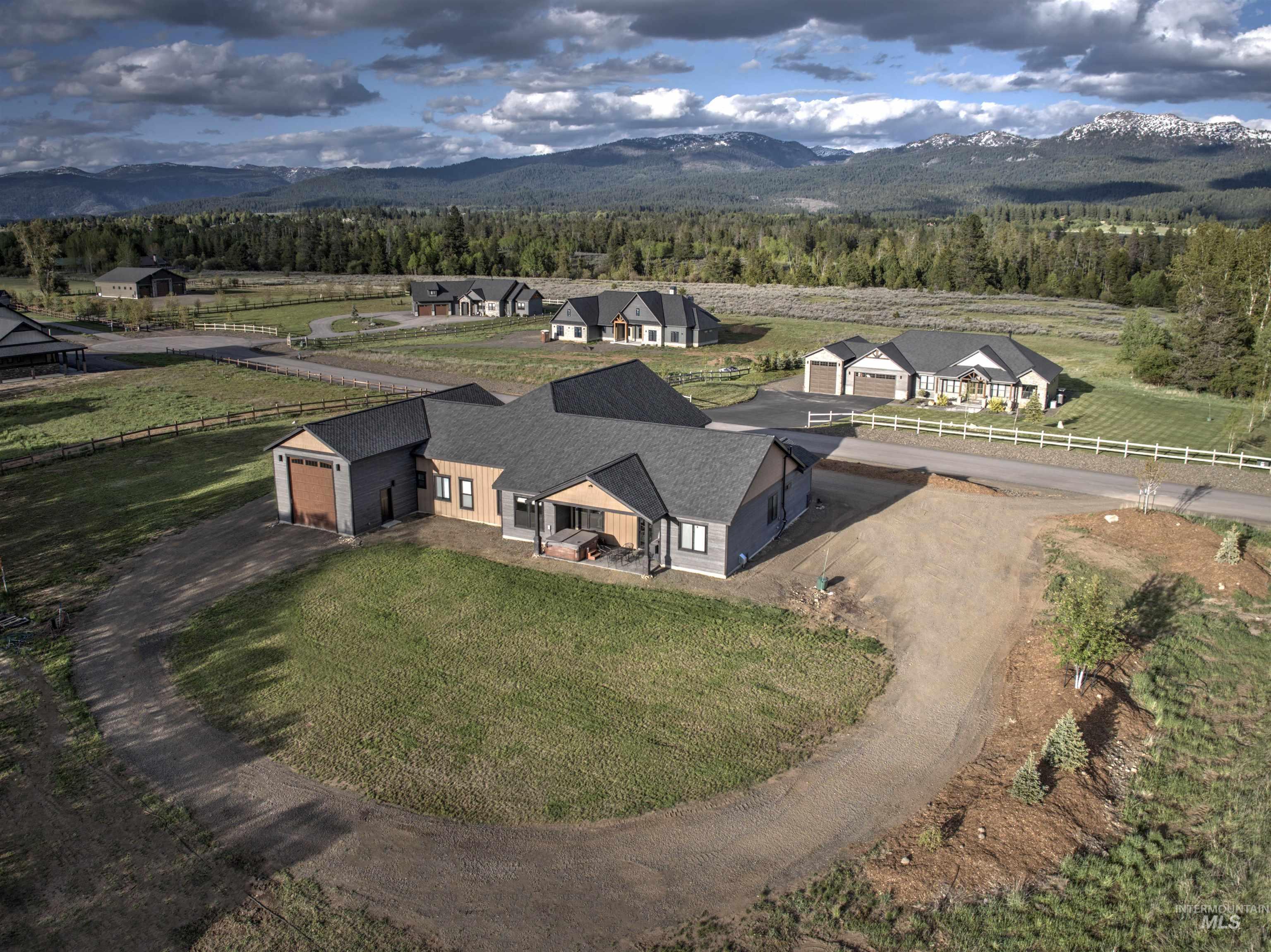Contemporary single-story residence with a gray shingle roof and a combination of horizontal tan and gray siding