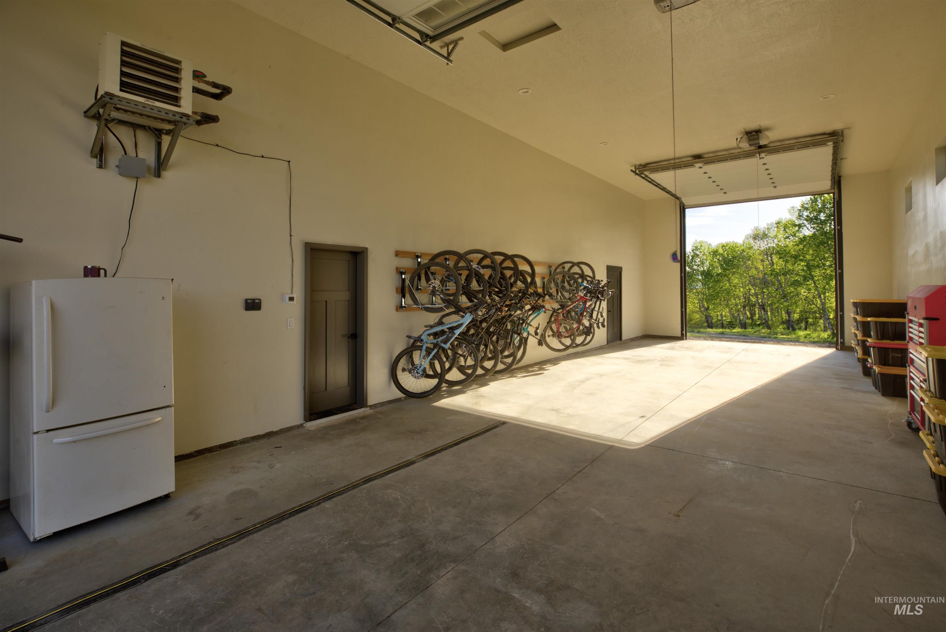 Spacious garage featuring a concrete floor, high ceilings, and an overhead door