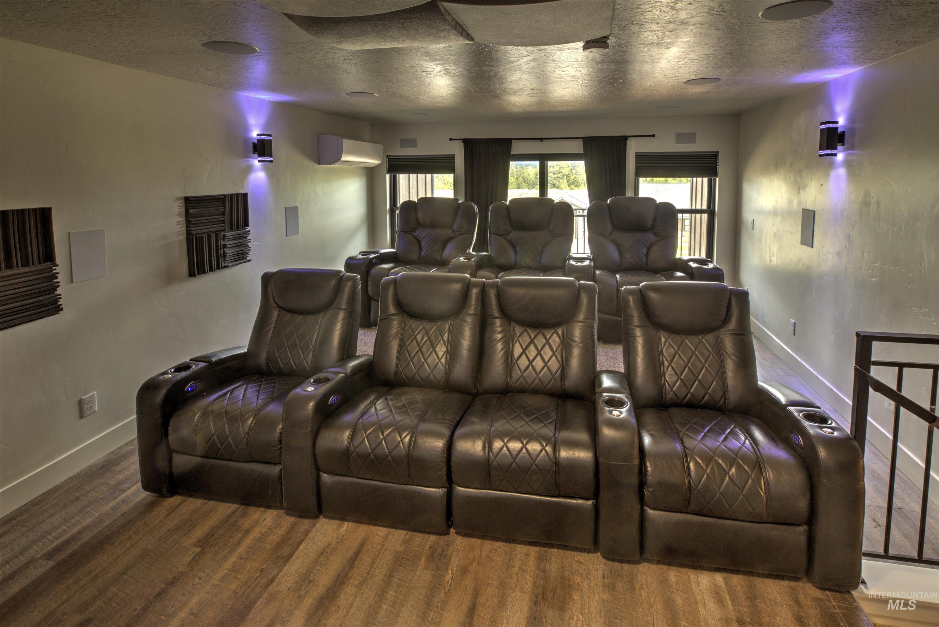 Dedicated media room featuring wood-finish flooring and integrated ceiling speakers