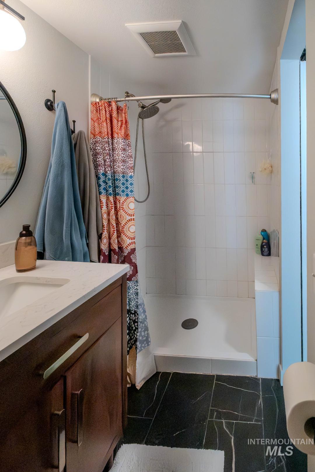 Bathroom with vanity and a shower stall