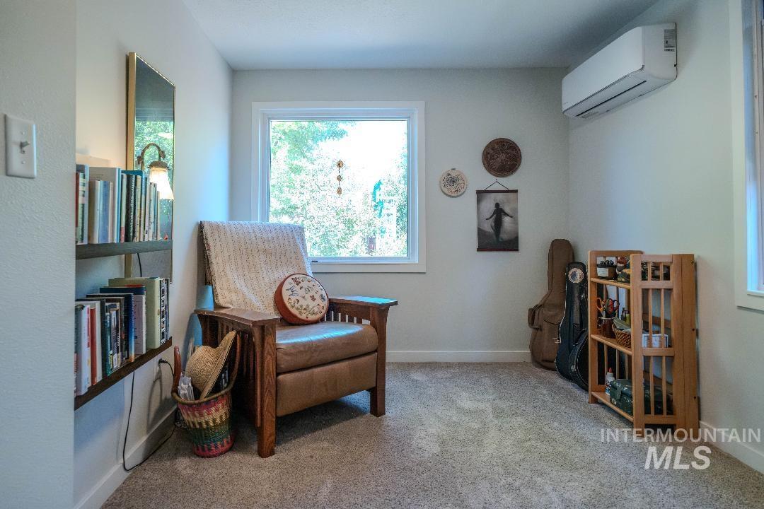Sitting room featuring carpet flooring and a wall mounted AC