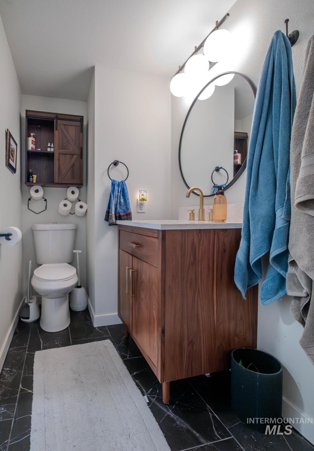 Bathroom with vanity and dark marble finish floors