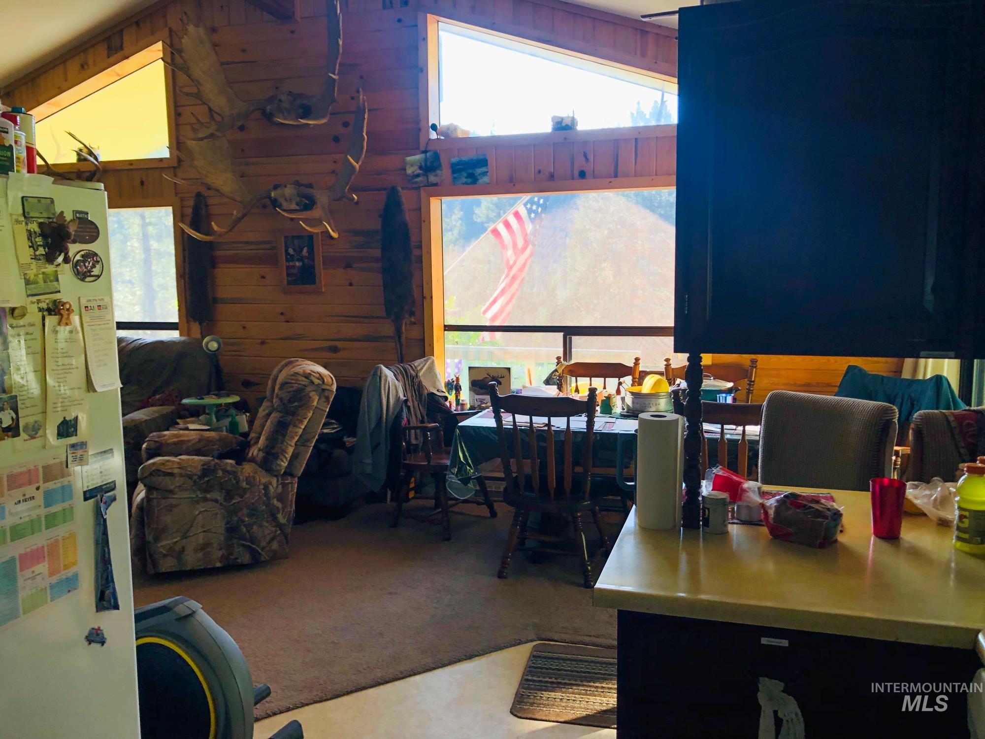 Dining area featuring wood walls, healthy amount of natural light, and carpet floors