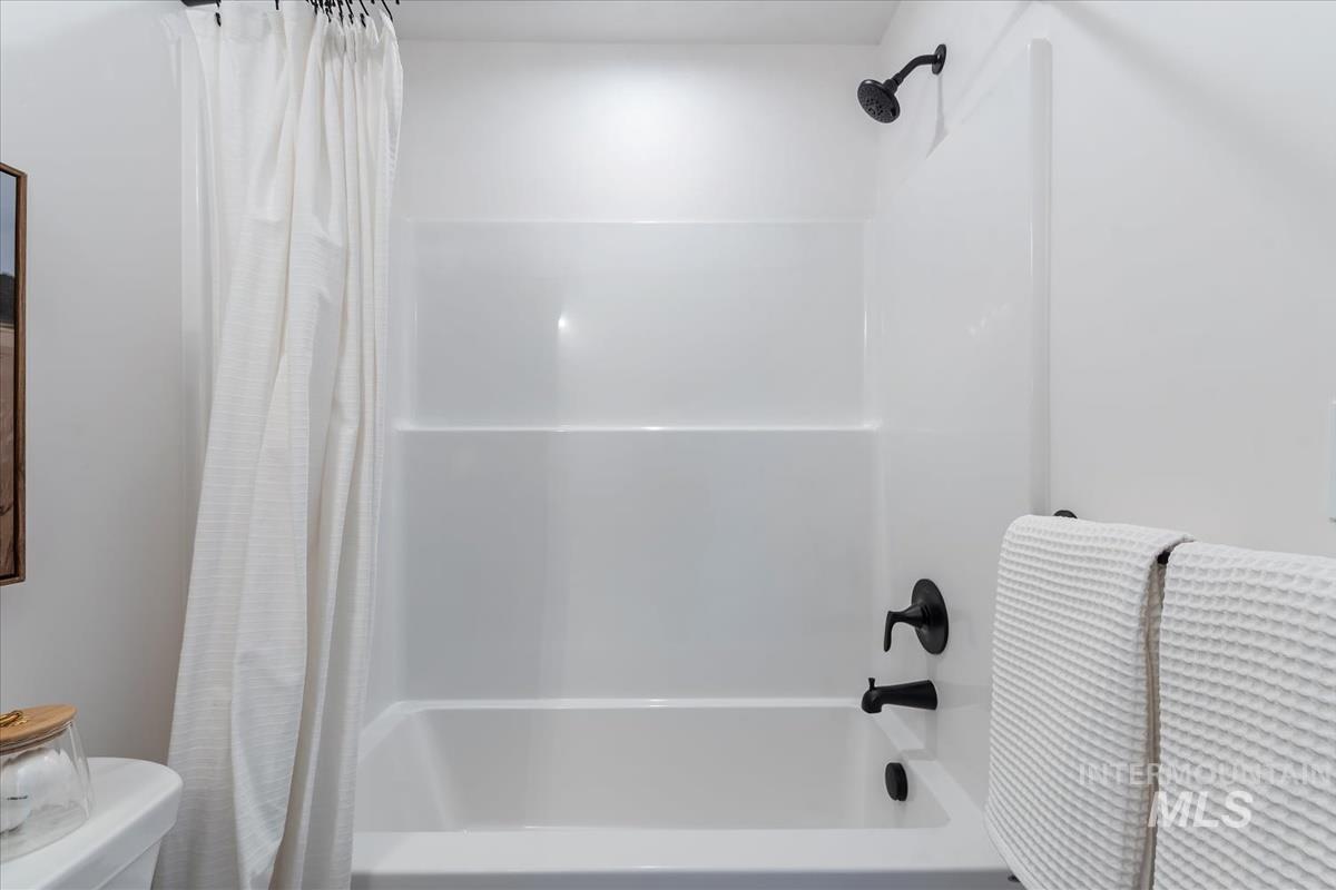 Full bathroom featuring shower / bathtub combination with curtain