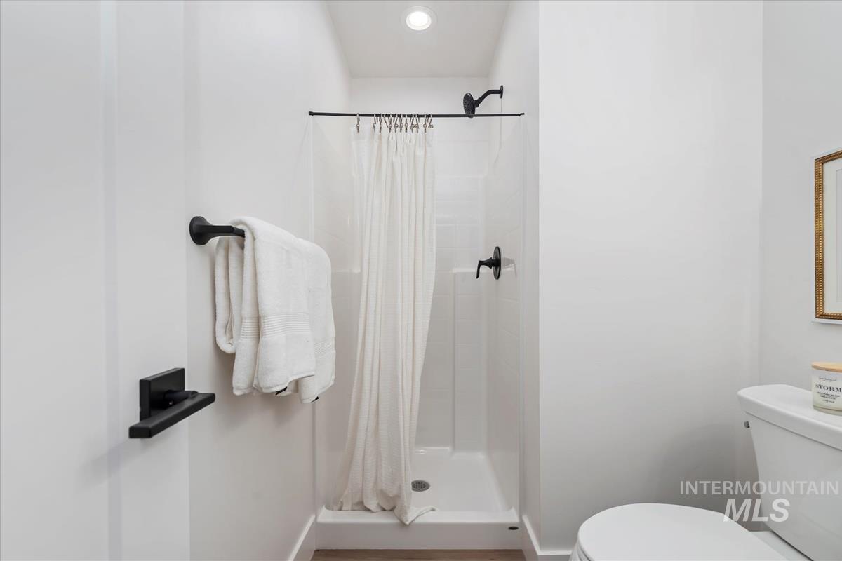 Bathroom featuring a stall shower and toilet