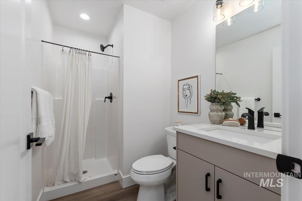 Bathroom with vanity, a shower stall, dark wood-style flooring, and recessed lighting