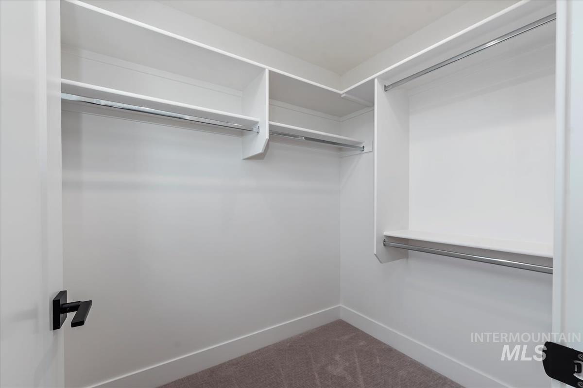 Walk in closet with dark carpet