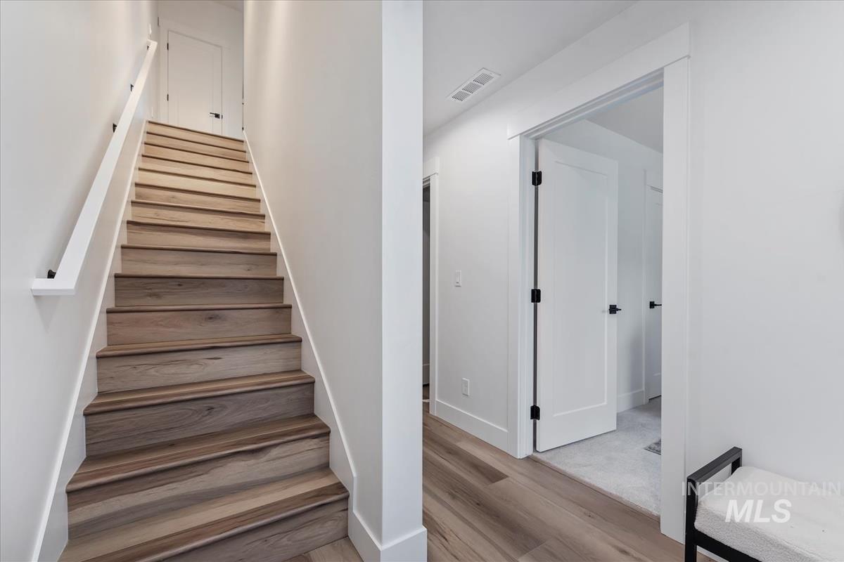 Stairs with wood finished floors and baseboards
