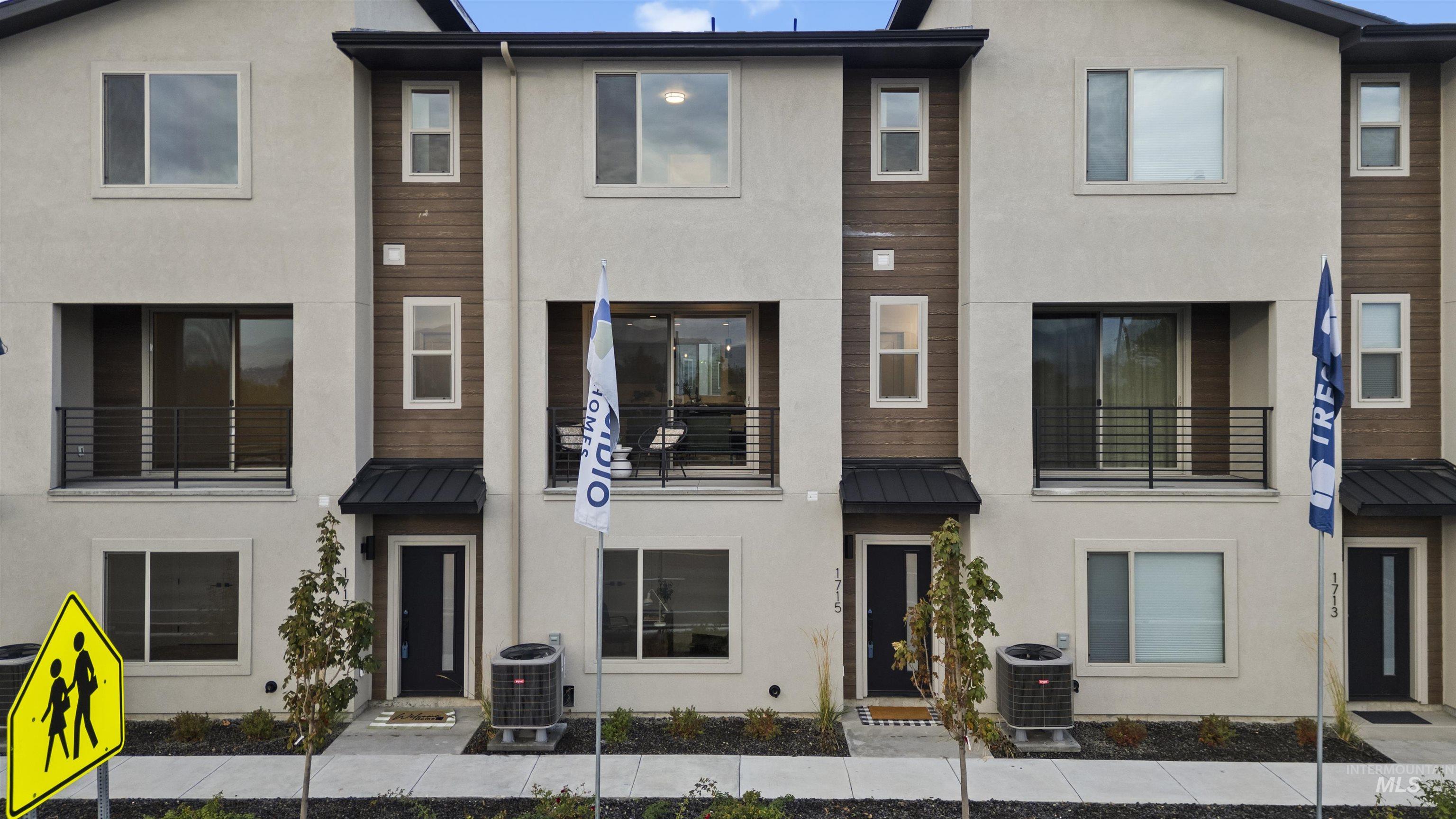 View of front facade featuring a standing seam roof, a metal roof, and stucco siding