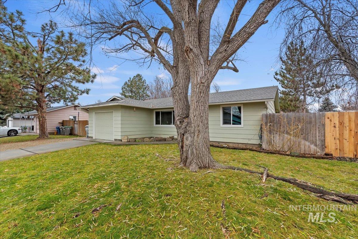 Single story home featuring concrete driveway and an attached garage