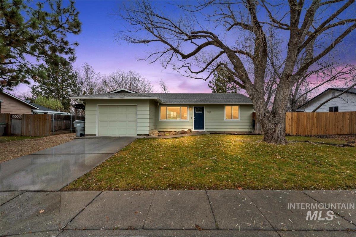 Ranch-style house featuring concrete driveway and an attached garage