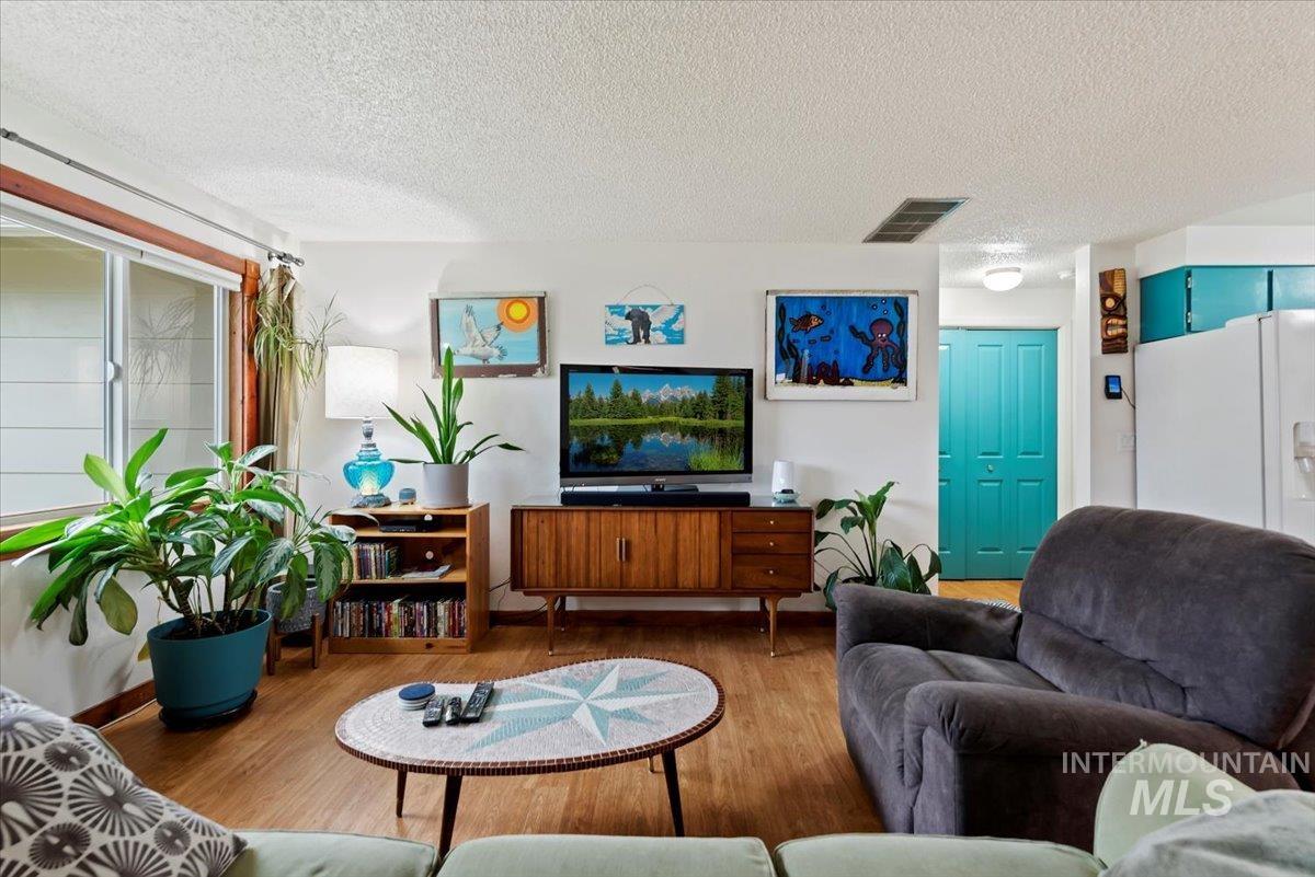 Living room with a textured ceiling and wood finished floors