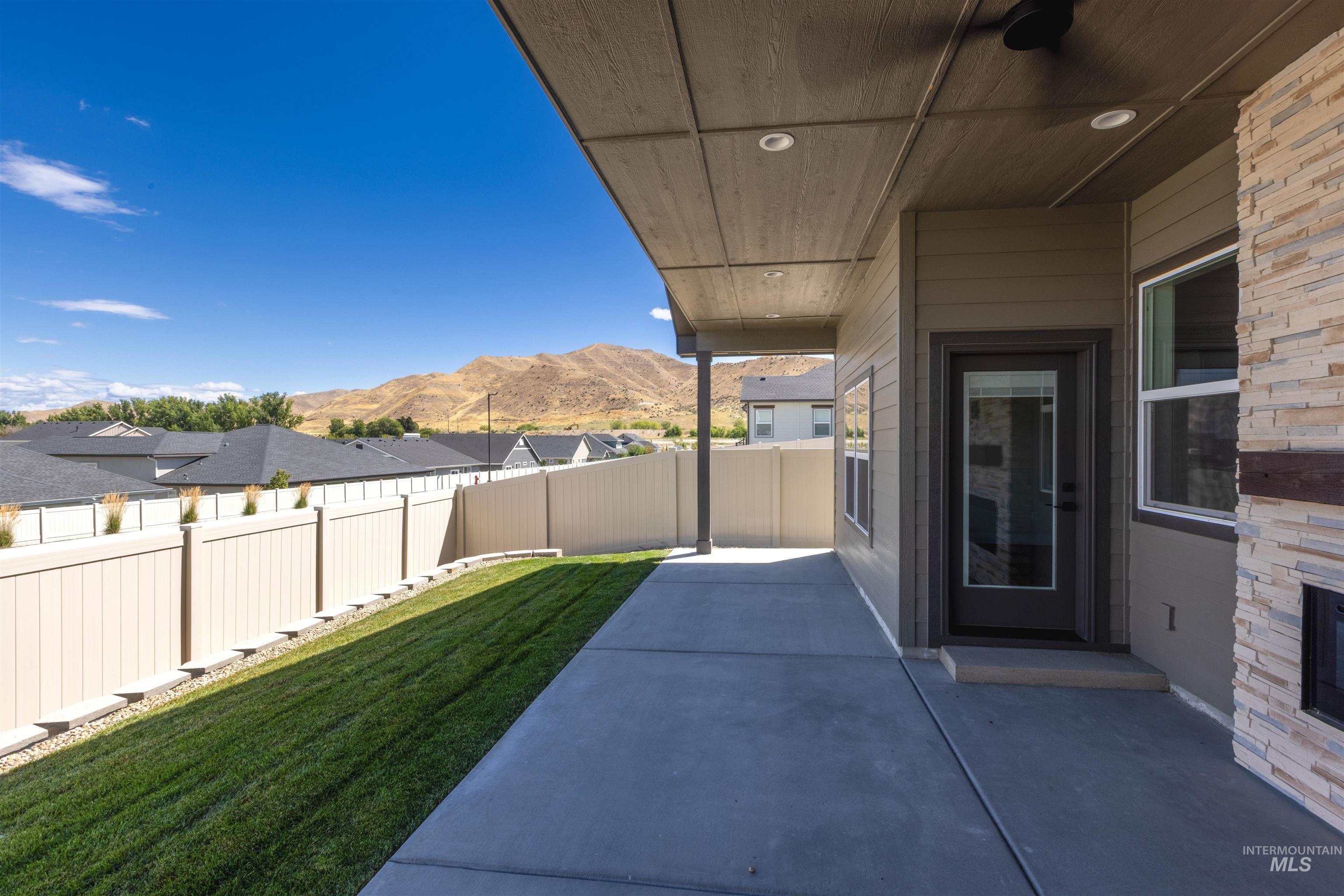 Fenced backyard featuring a mountain view, a patio area, and a residential view