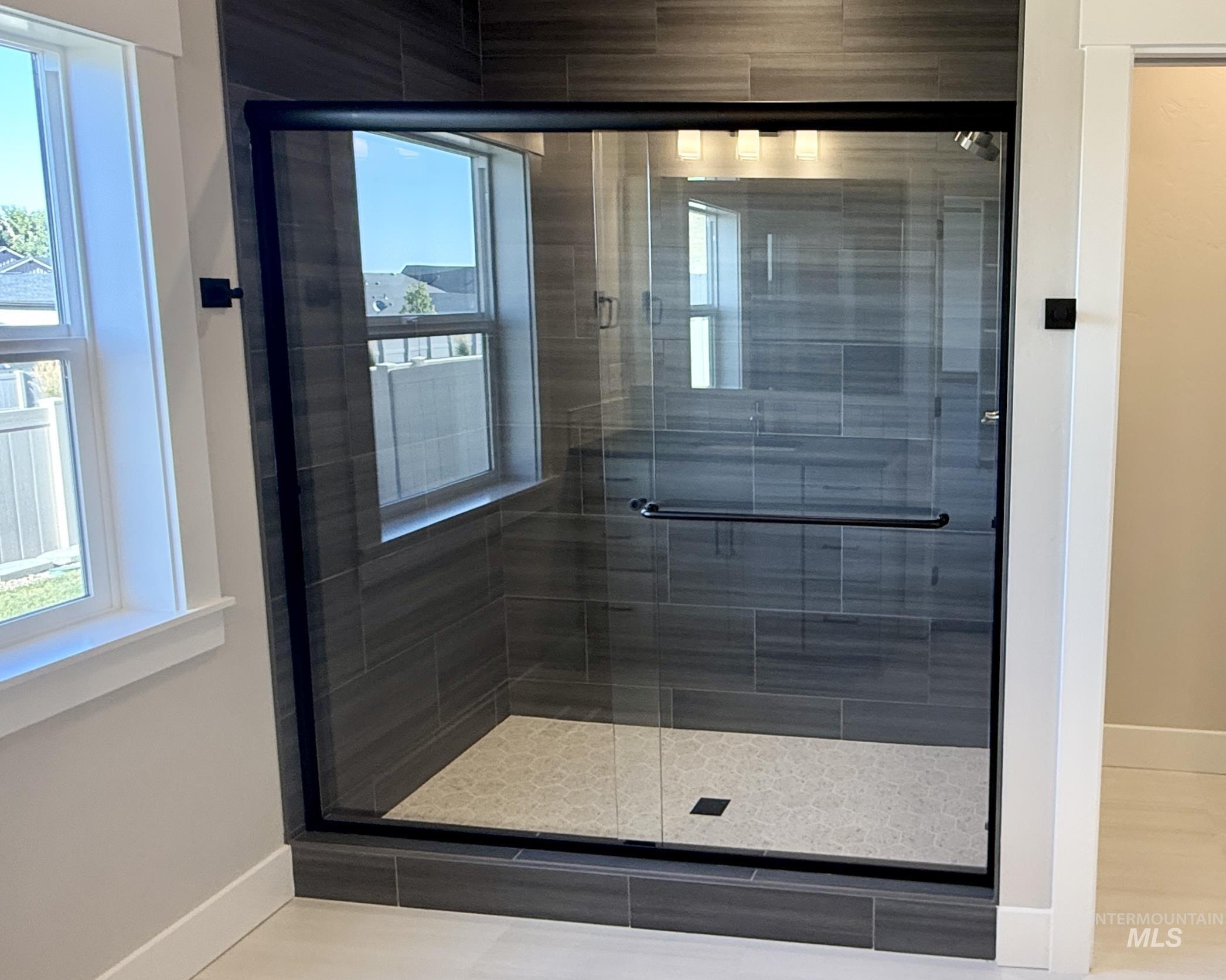 Bathroom with a stall shower and tile patterned floors