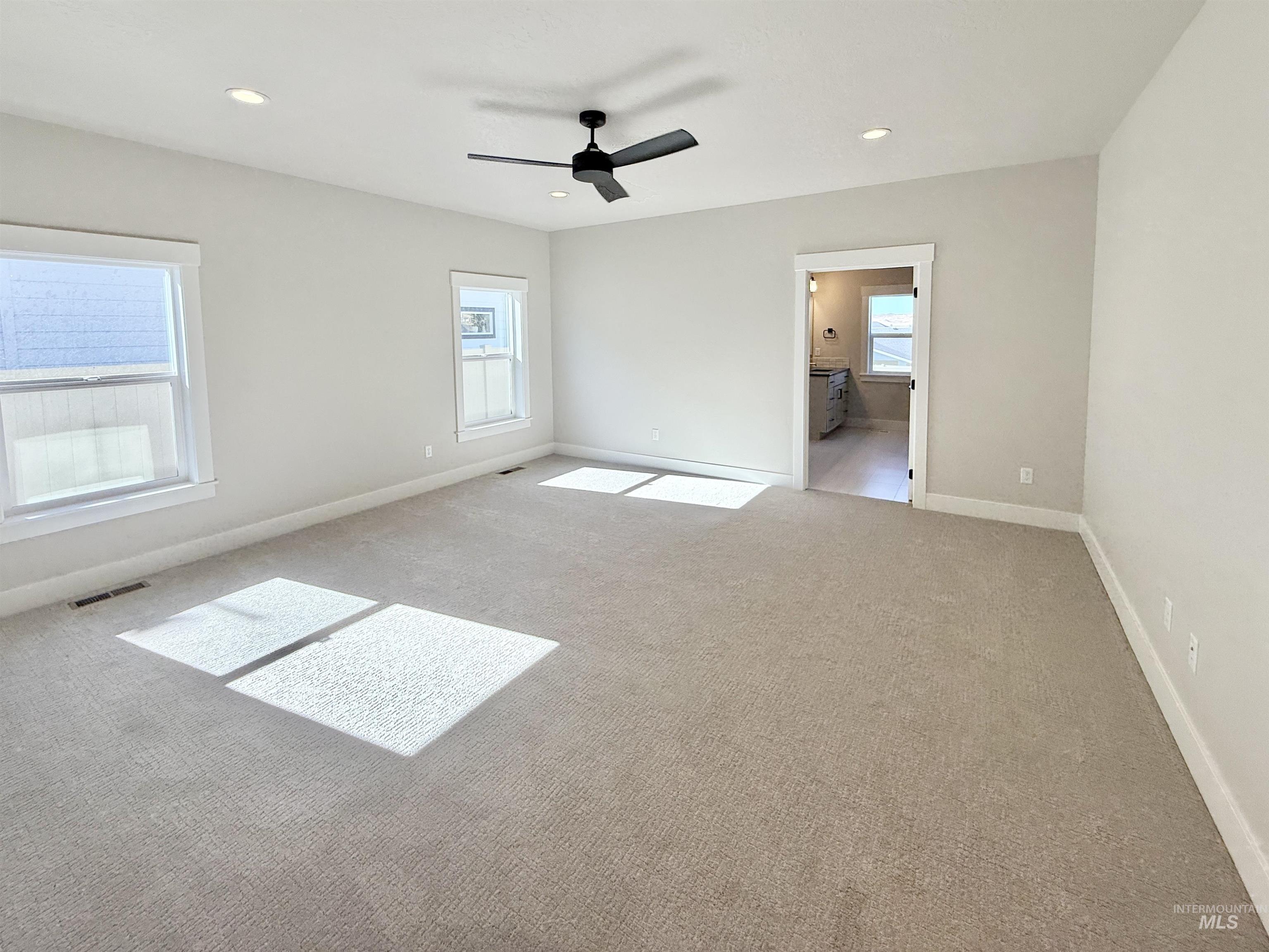 Unfurnished bedroom with carpet floors, recessed lighting, a ceiling fan, and ensuite bath