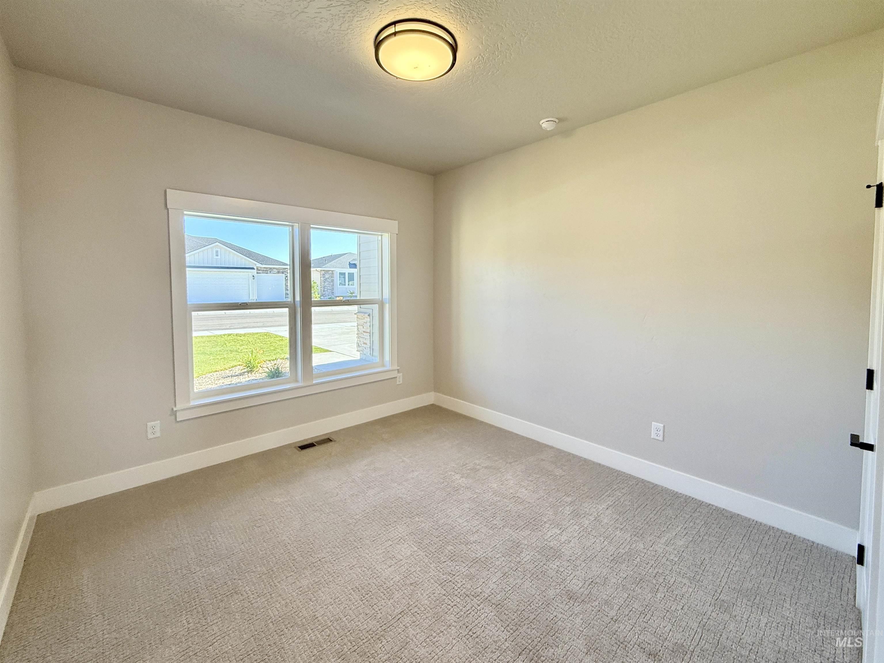 Unfurnished room featuring carpet and a textured ceiling